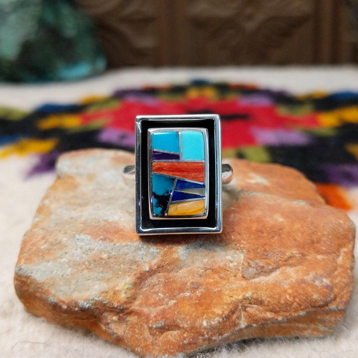 Navajo multistone mosaic shadowbox ring by A.Y. with geometric inlay and rectangular silver frame.
