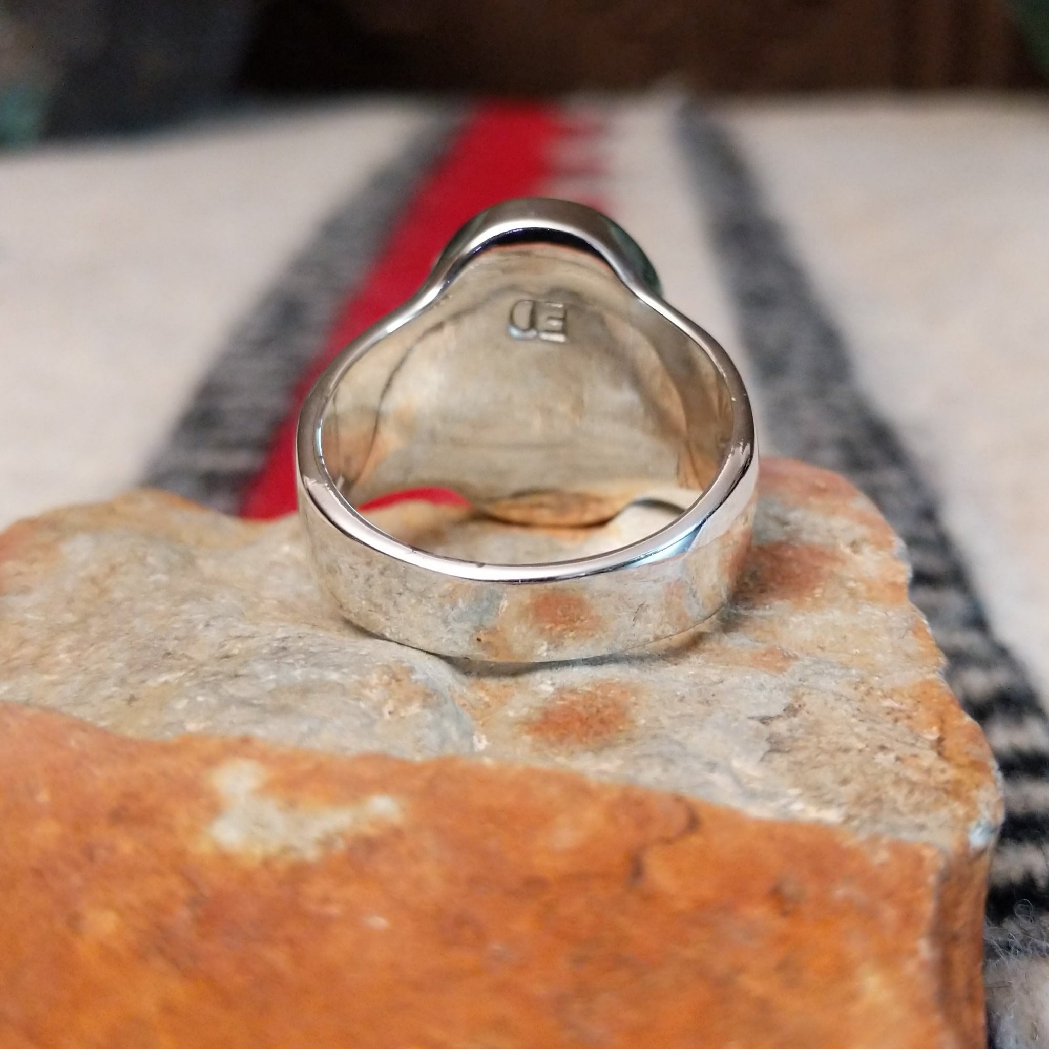 Navajo oval multistone inlay ring by E.D. featuring turquoise, blue, green, and purple stones arranged in a geometric mosaic with silver channel accents and a polished silver band; underside view.