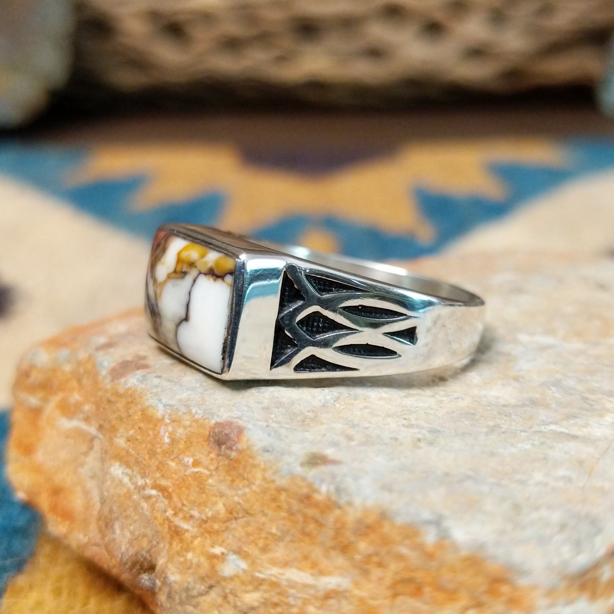 Handcrafted Navajo sterling silver ring featuring a rectangular Wild Horse gemstone with natural white, brown, and golden veining, set in a smooth bezel with openwork cutout details on the band; side view.