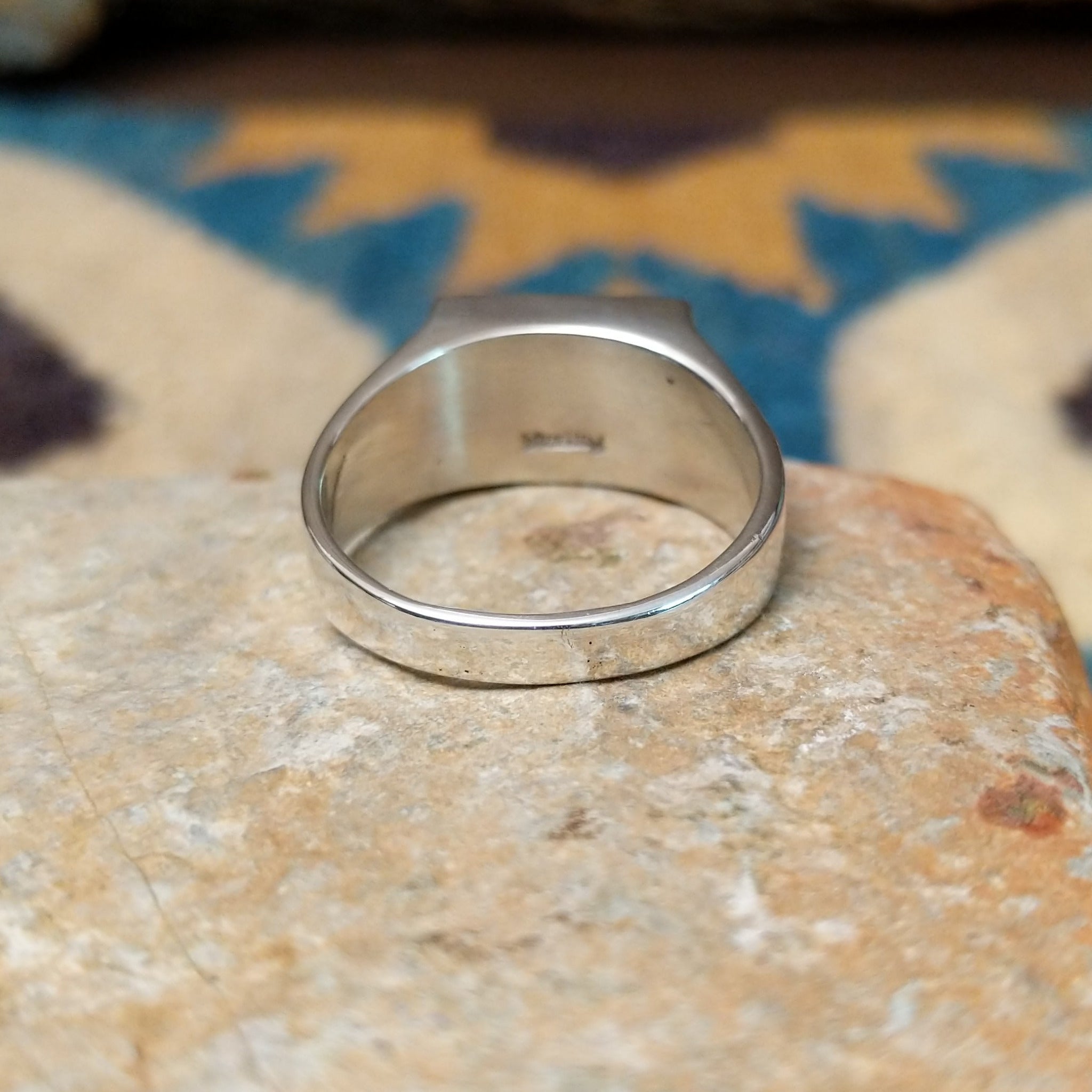 Handcrafted Navajo sterling silver ring featuring a rectangular Wild Horse gemstone with natural white, brown, and golden veining, set in a smooth bezel with openwork cutout details on the band; underside view.