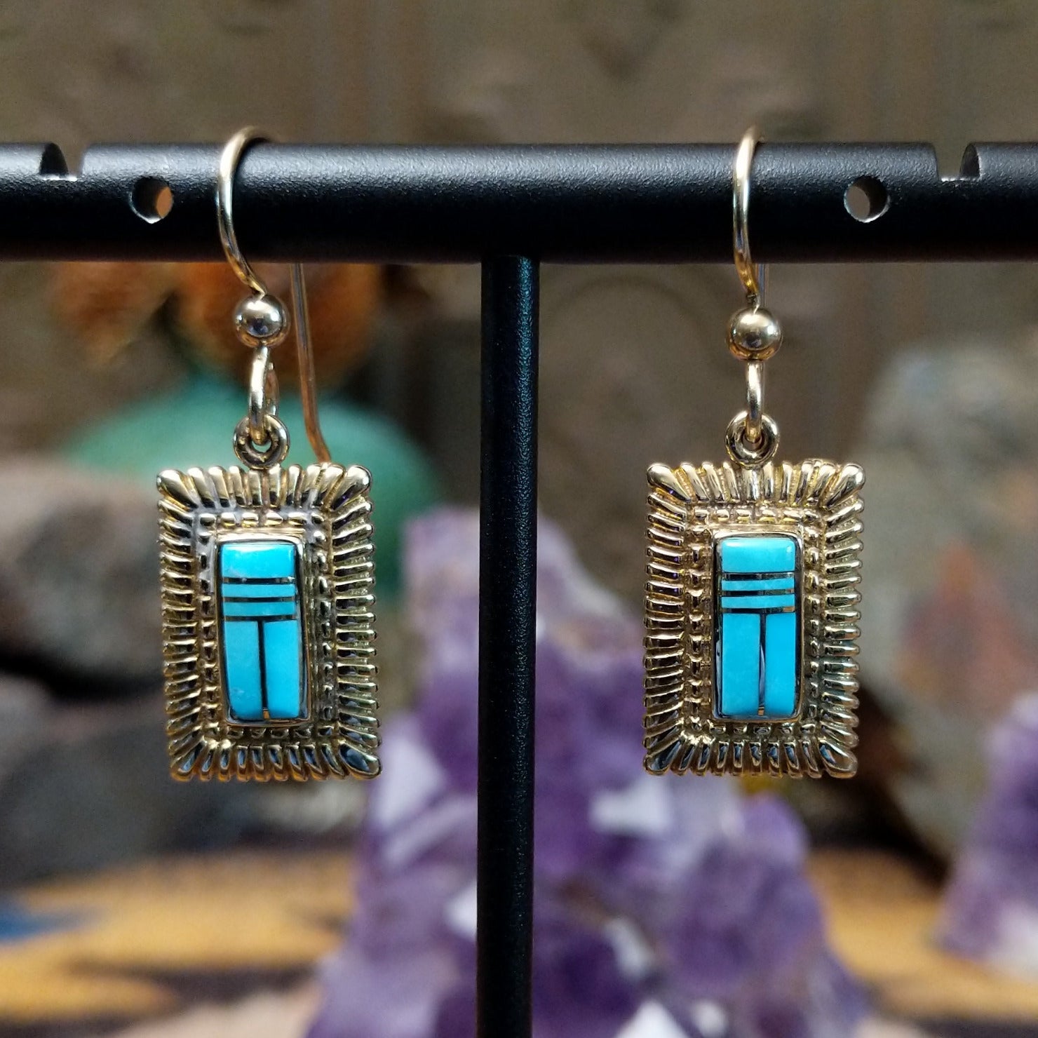 14kt gold Navajo dangle earrings featuring rectangular turquoise inlay with geometric line details and textured gold frames.