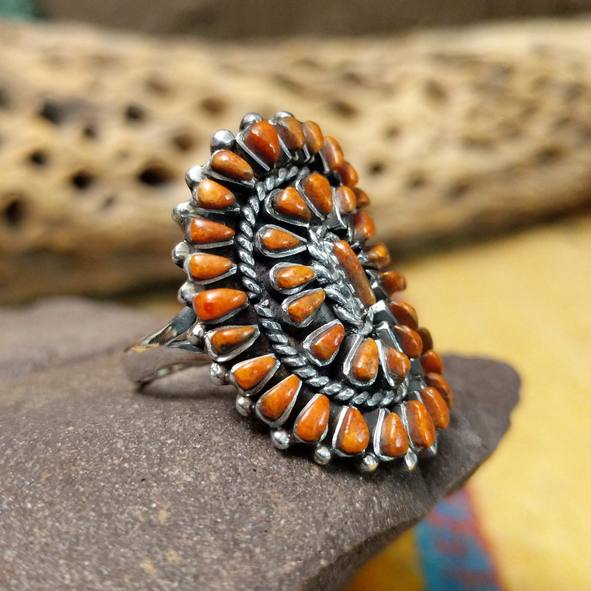 Navajo red spiny oyster shell concho ring, featuring a vibrant red spiny oyster shell set in a handcrafted sterling silver concho-style band with traditional Southwestern details. Side view.