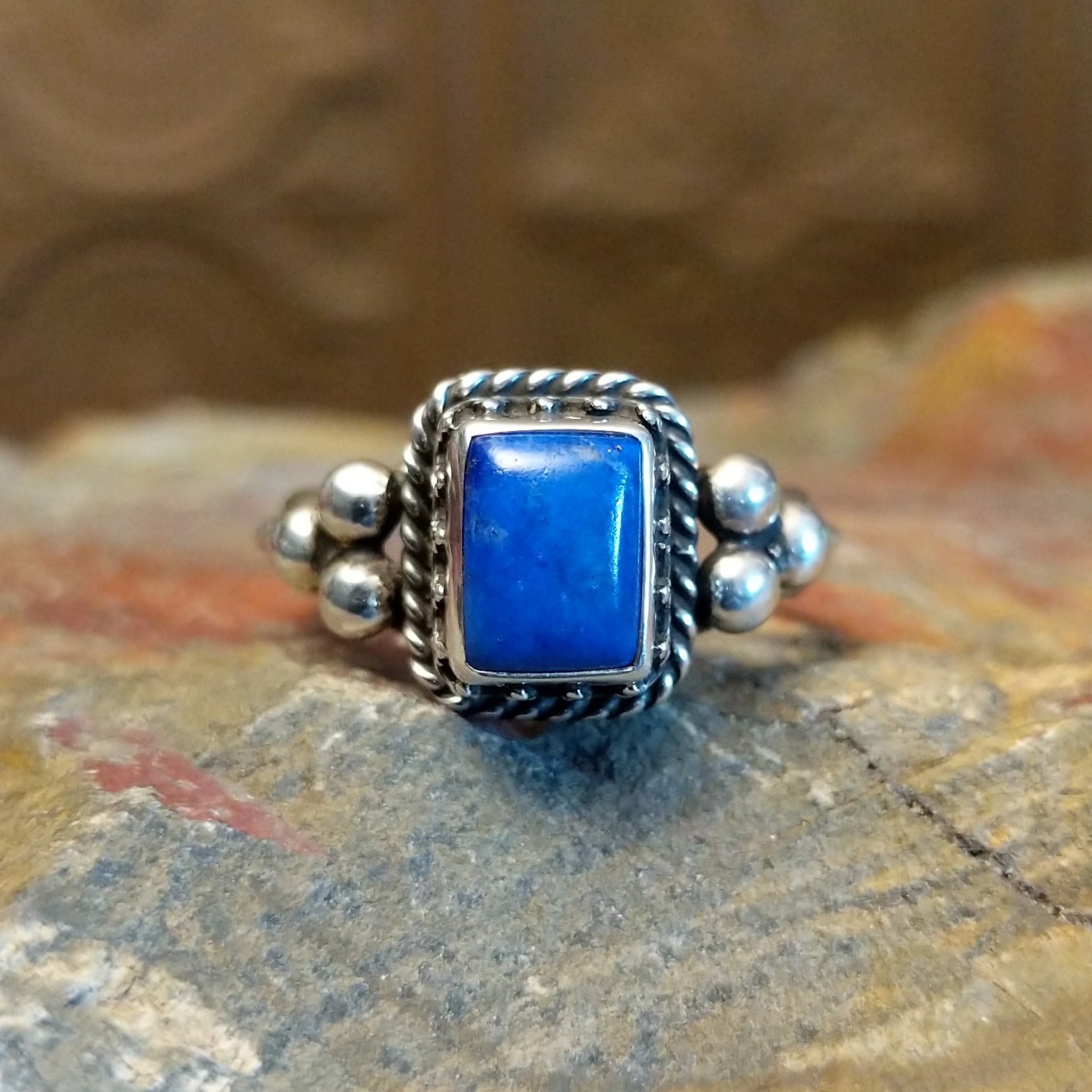 Sterling silver ring with lapis set in the square bezel, framed by twisted rope and dotted accents.