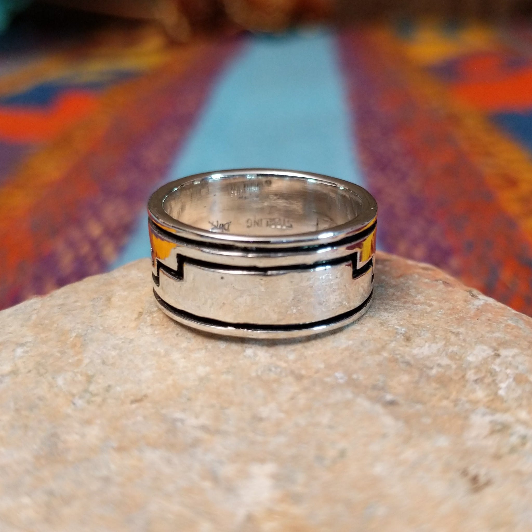 Navajo silver ring by I. Kee with Kokopelli figure and recessed geometric design.