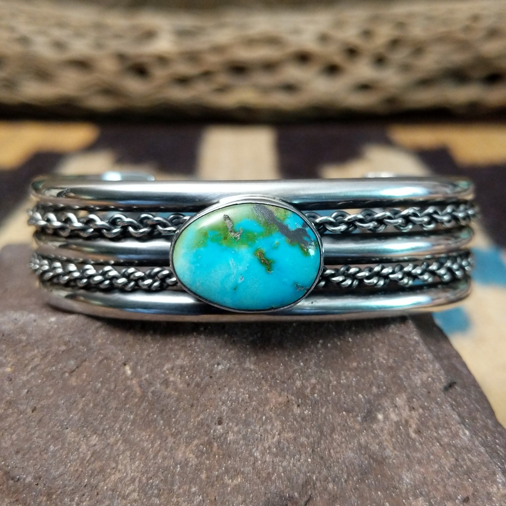 Navajo Sonoran Gold turquoise cuff by H.R.M., featuring an oval blue and green Sonoran Gold turquoise stone with natural matrix set in a handcrafted sterling silver cuff with twisted chain accents.
