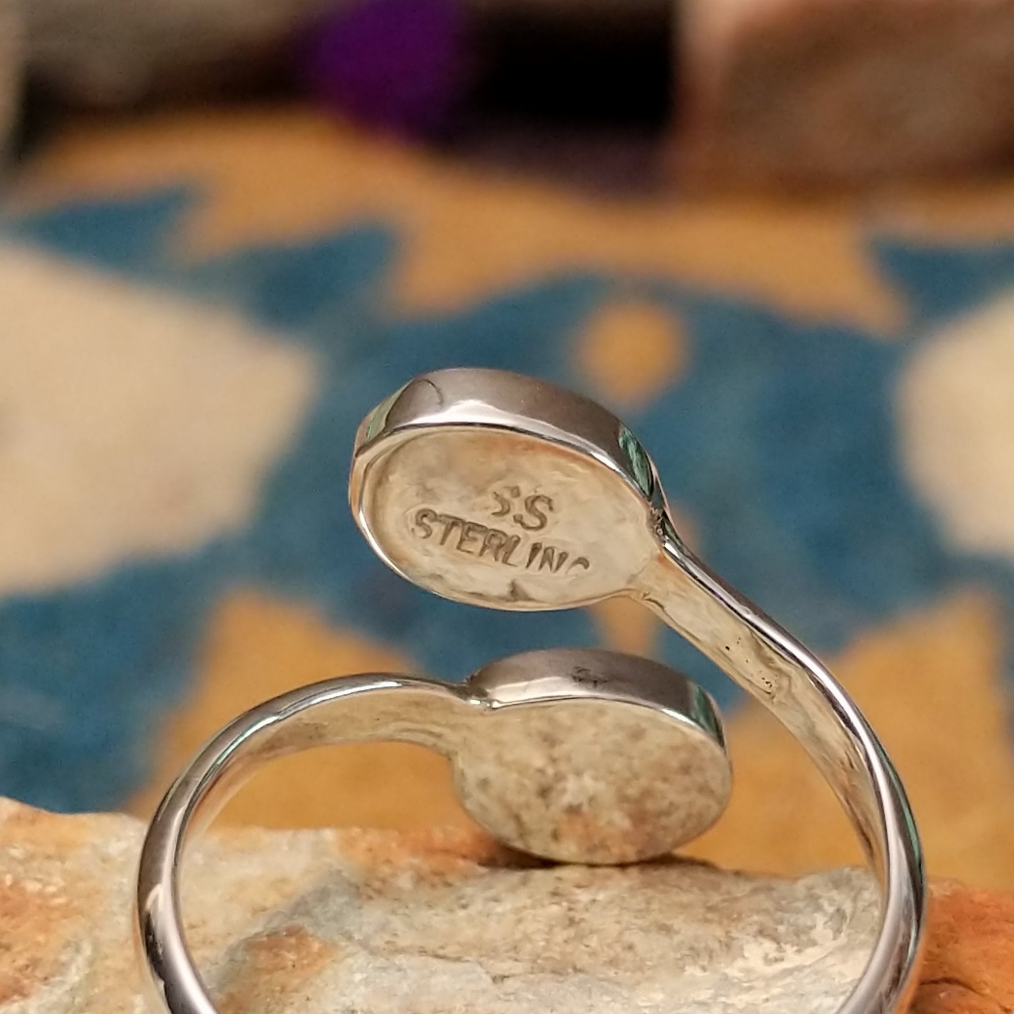 Handcrafted Navajo sterling silver bypass ring featuring two oval Sonoran Gold turquoise cabochons in smooth bezel settings, with vibrant blue and green natural turquoise on a polished open-band design; artisan and Sterling Silver stamp.