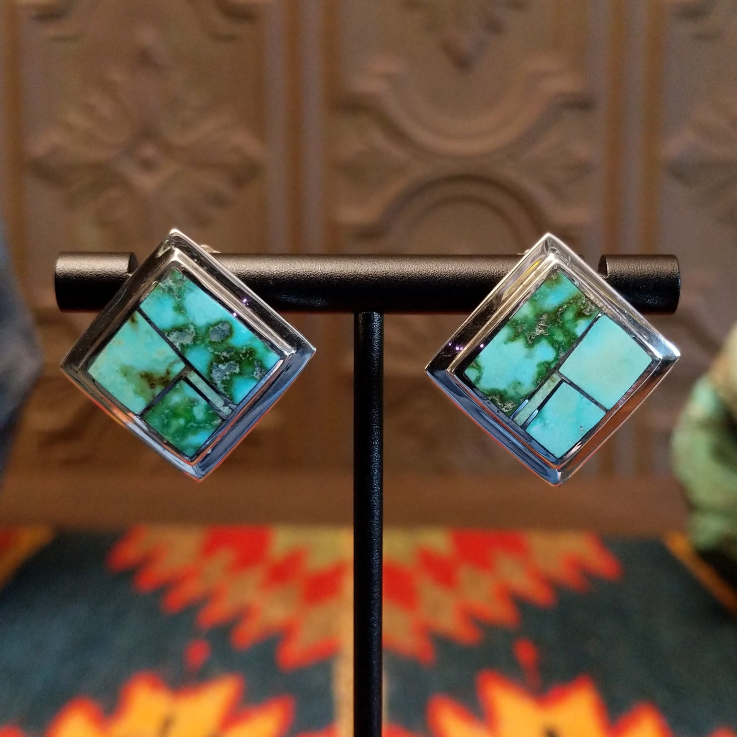 Sterling silver earrings with Sonoran Gold turquoise inlays, framed by the diamond settings.