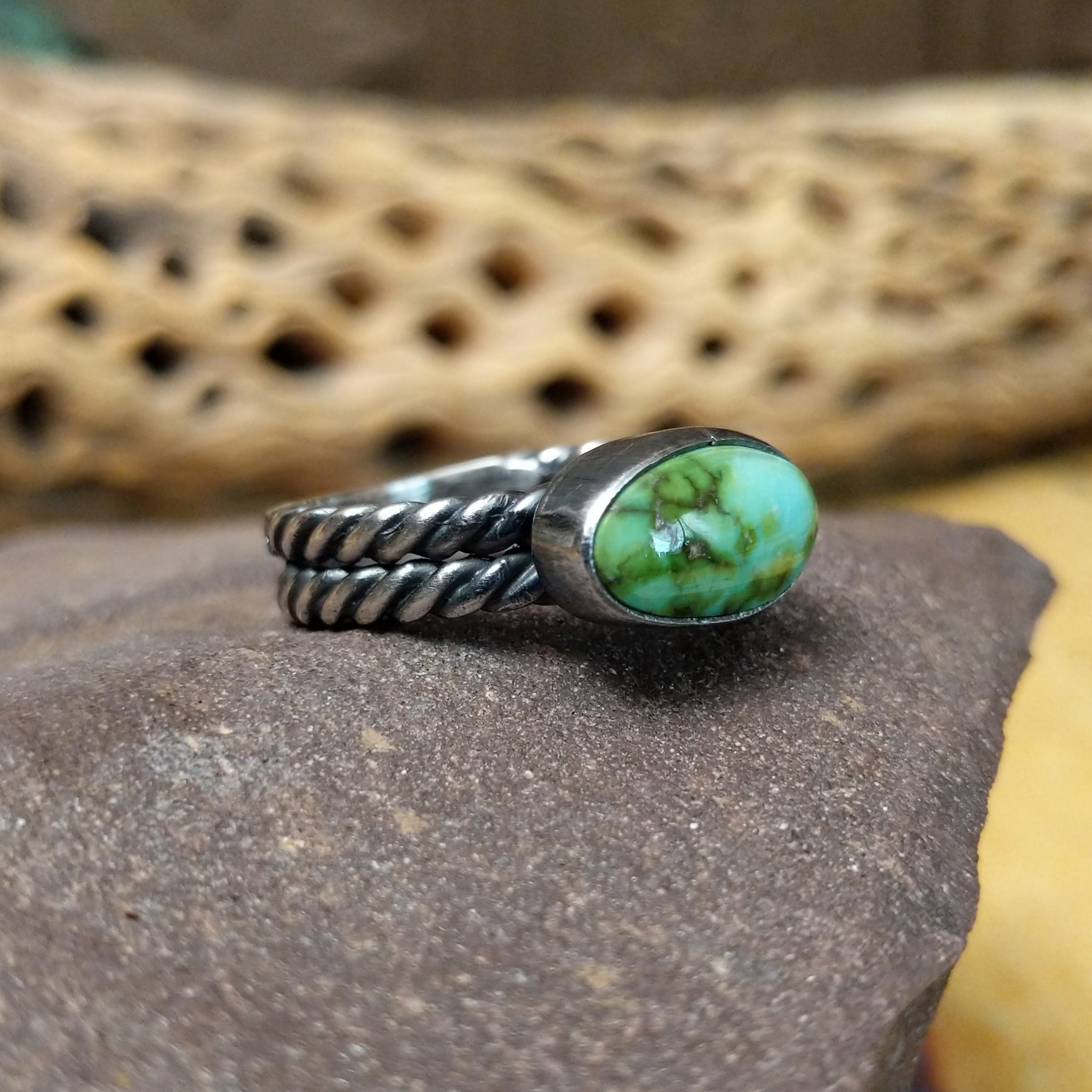 Navajo Sonoran Gold turquoise roped ring, featuring a blue and green Sonoran Gold turquoise stone surrounded by a twisted rope border in a handcrafted sterling silver band. Side view.