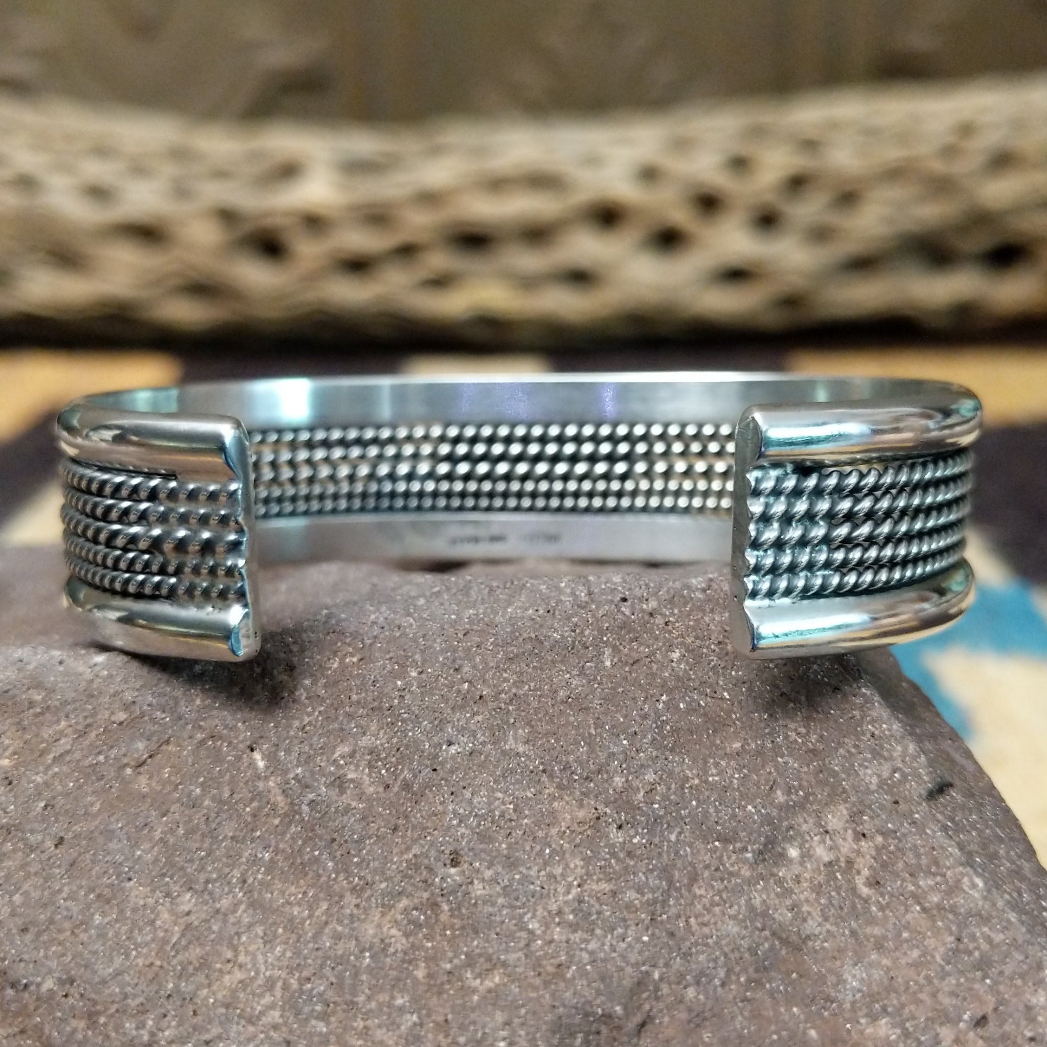 Navajo Sonoran Gold turquoise cuff by H.R.M. with a natural blue-green turquoise stone on a triple-shank sterling silver cuff; underside view.