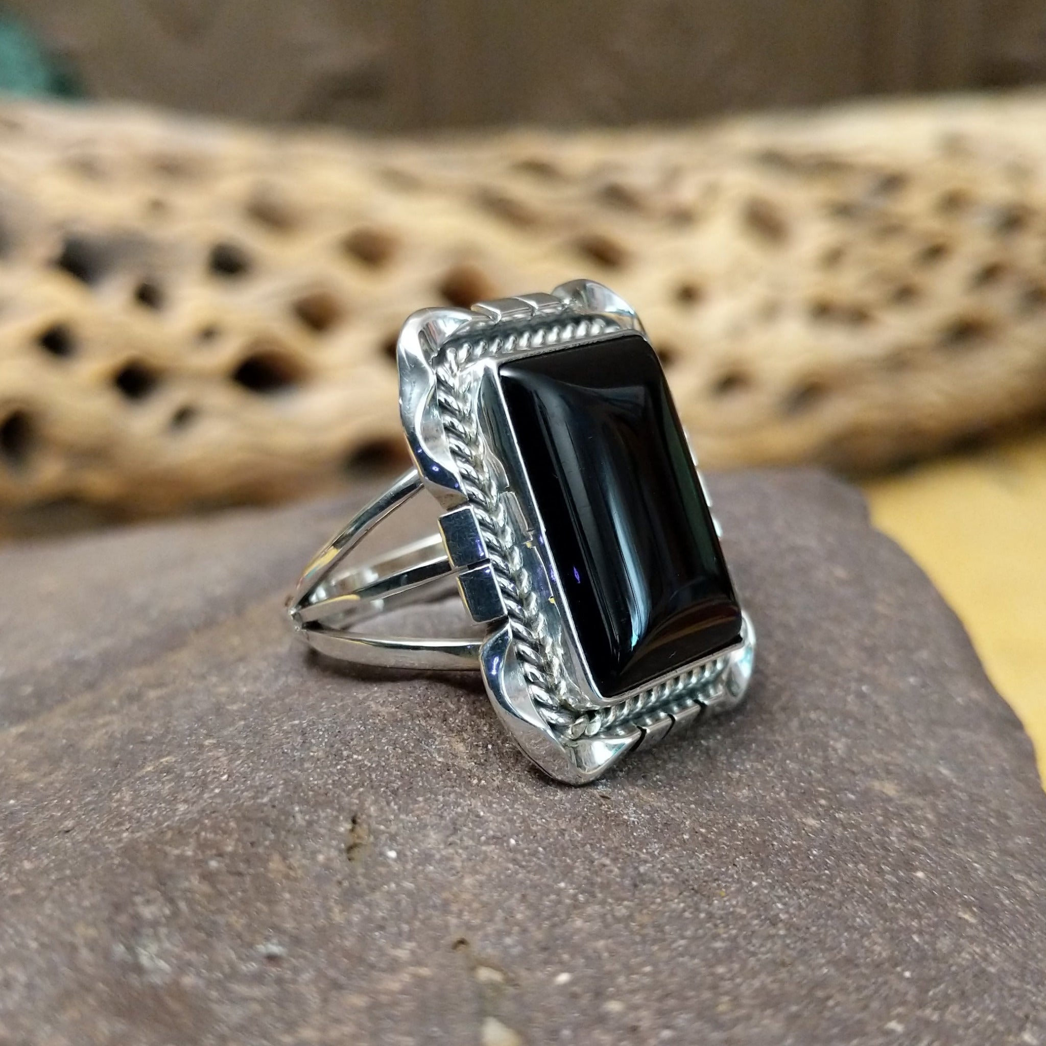Navajo square black onyx ring, featuring a polished square black onyx stone set in handcrafted sterling silver with traditional Southwestern-inspired metalwork. Side view.