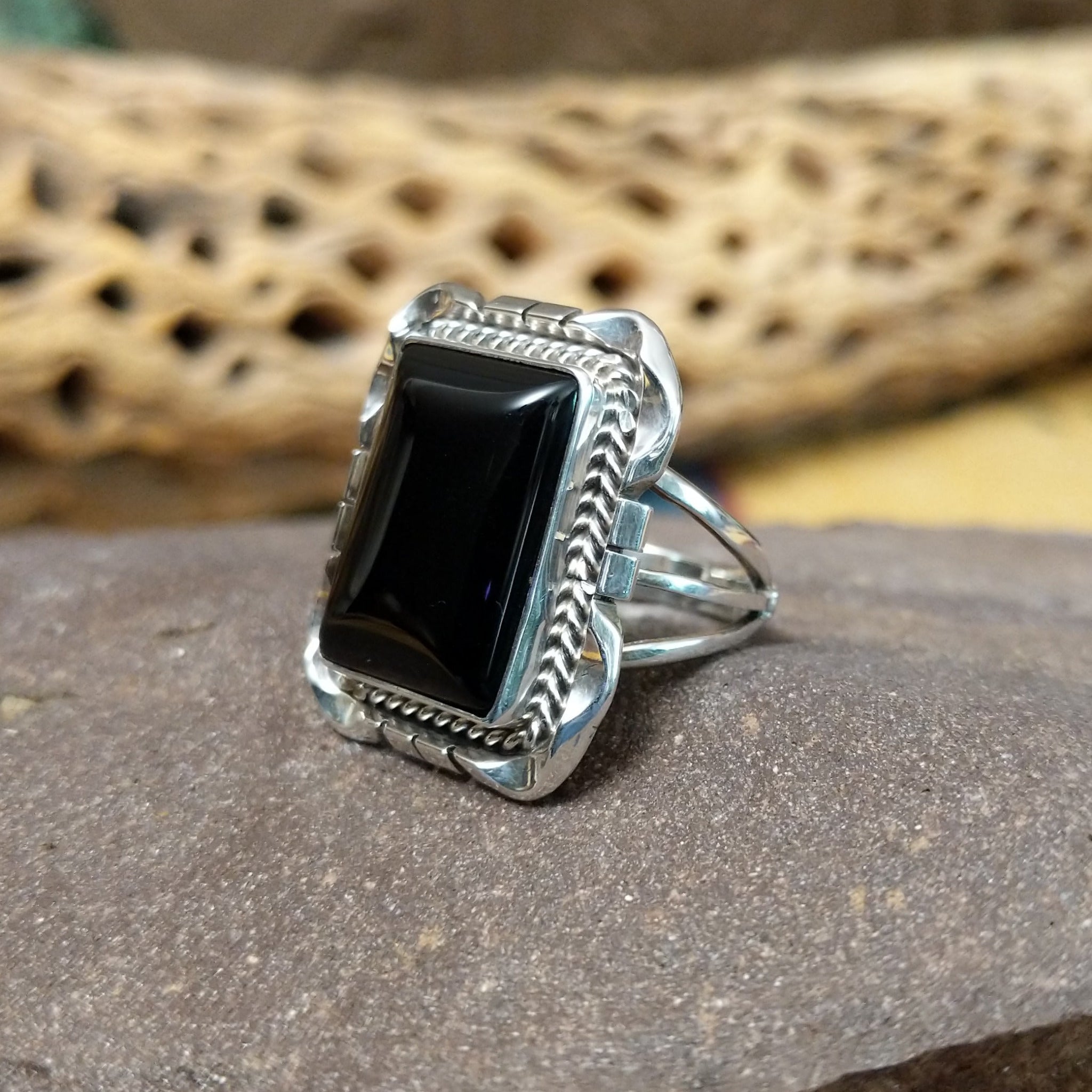 Navajo square black onyx ring, featuring a polished square black onyx stone set in handcrafted sterling silver with traditional Southwestern-inspired metalwork. Side view.