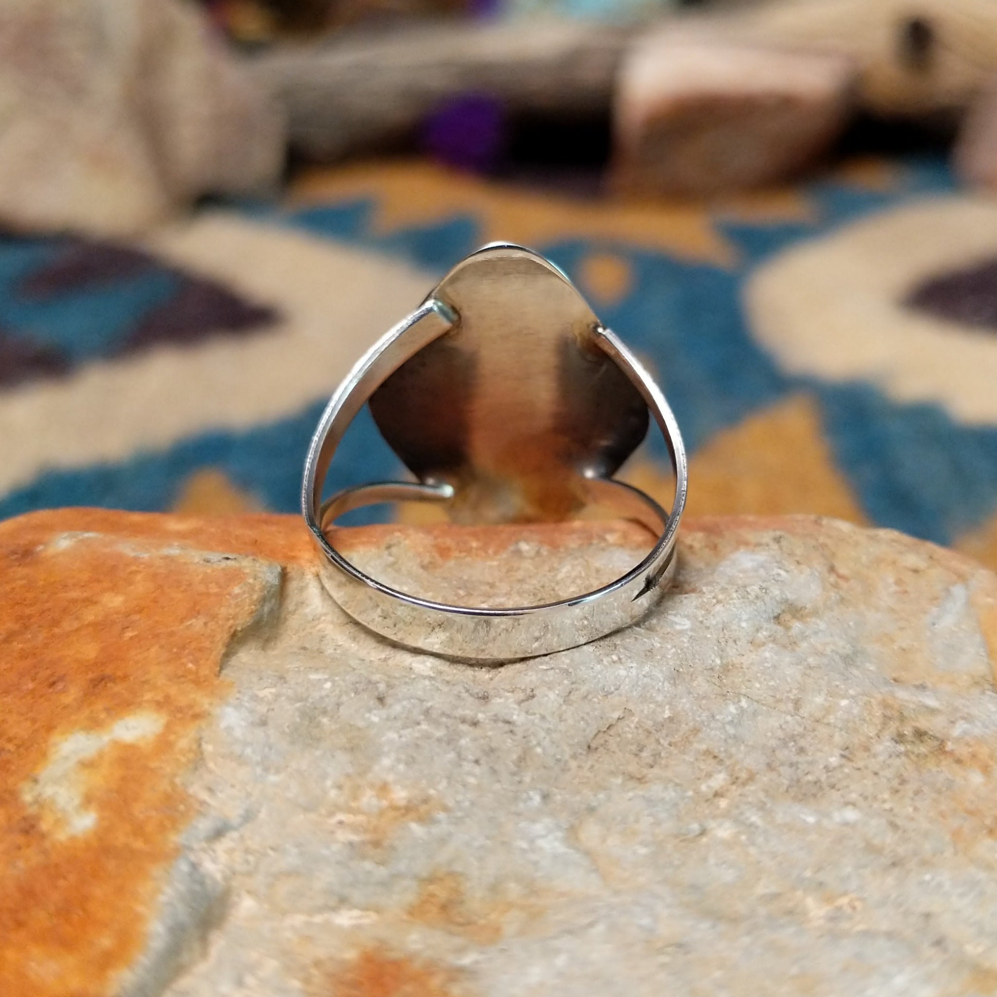 Handcrafted Navajo sterling silver shadowbox ring by P. featuring an oval turquoise cabochon set within a stepped geometric shadowbox design with hand-stamped details and an oxidized finish; underside view.