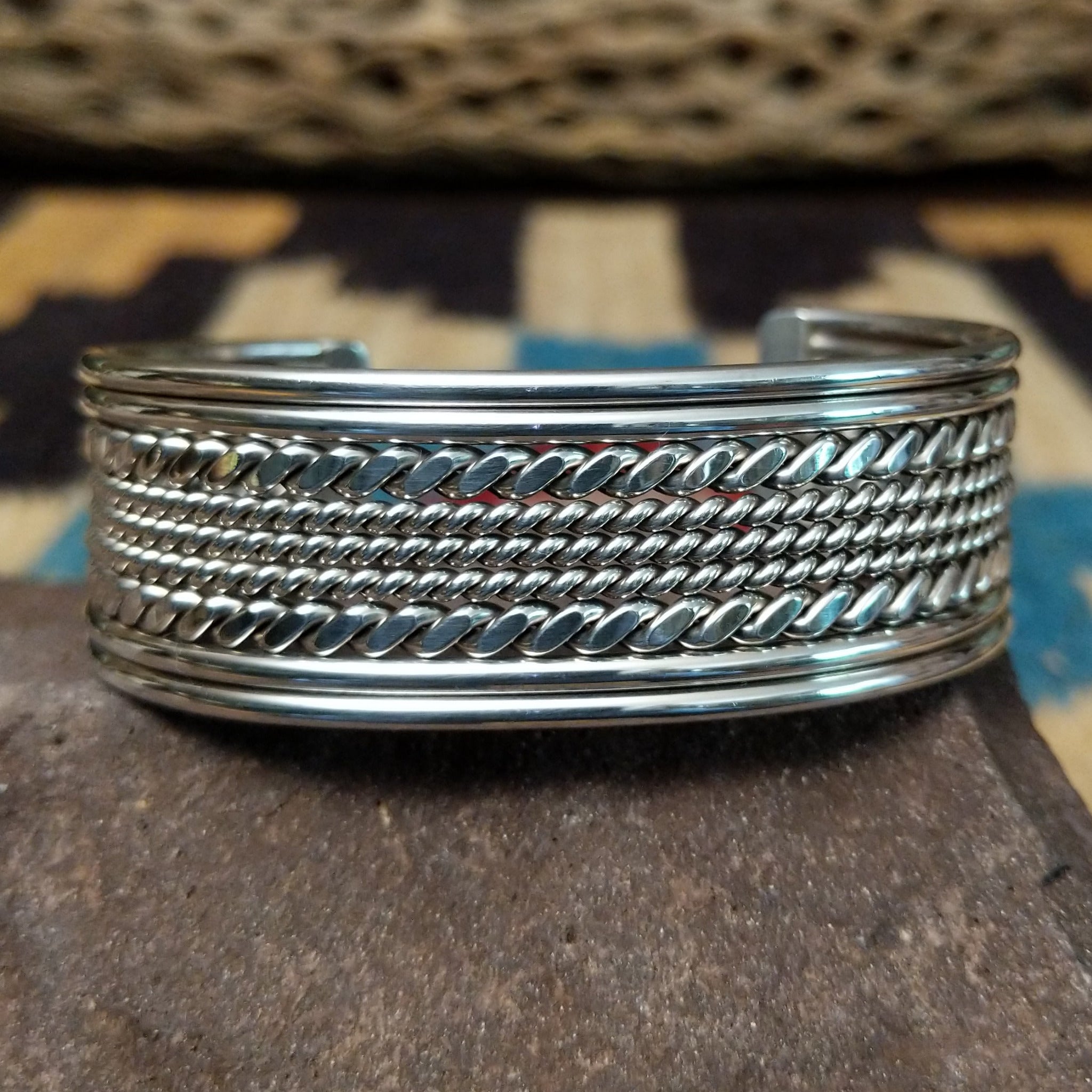 Navajo suspended sterling silver cuff, featuring layered twisted rope and polished silver strands in a handcrafted open cuff design with traditional Southwestern craftsmanship.