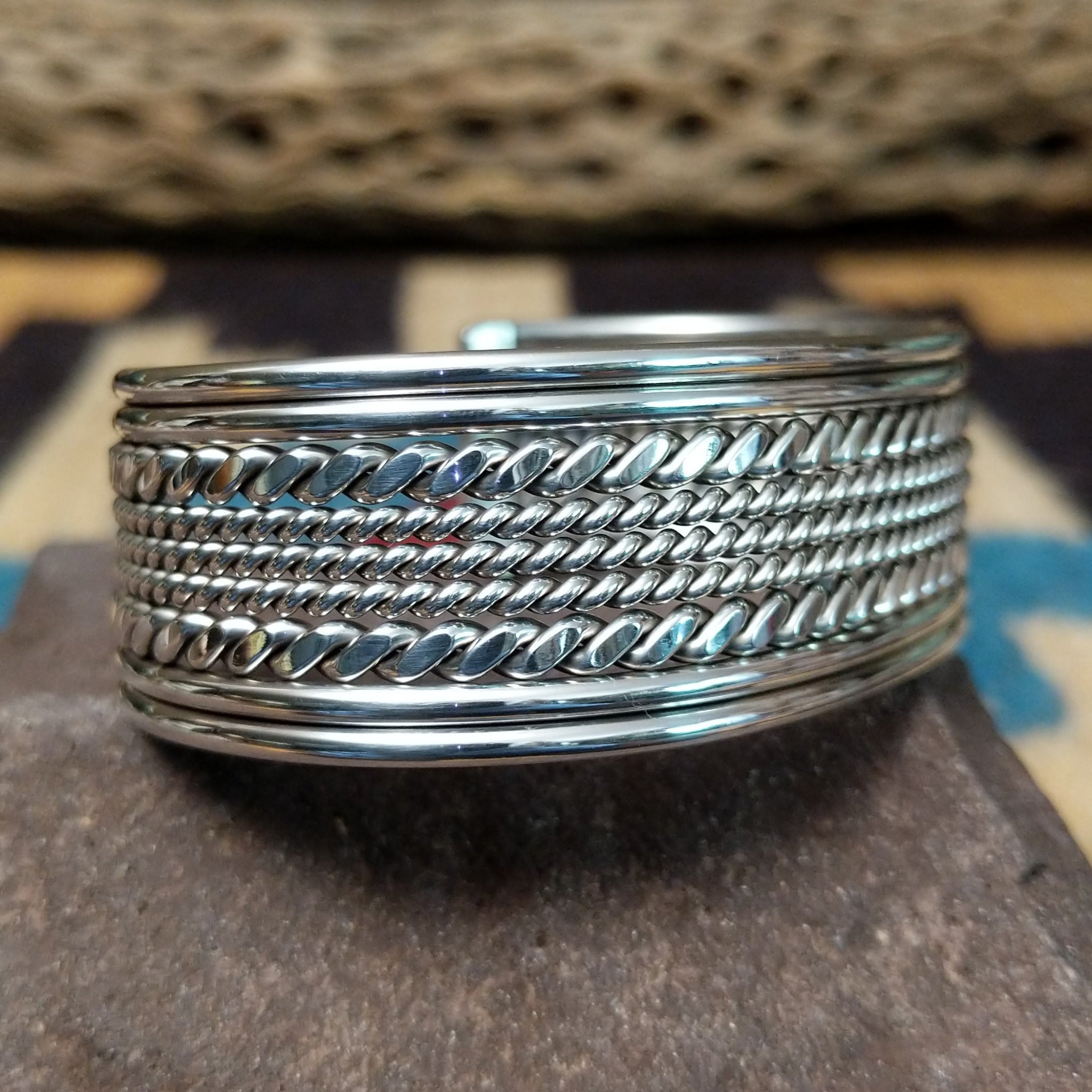 Navajo suspended sterling silver cuff, featuring layered twisted rope and polished silver strands in a handcrafted open cuff design with traditional Southwestern craftsmanship.
