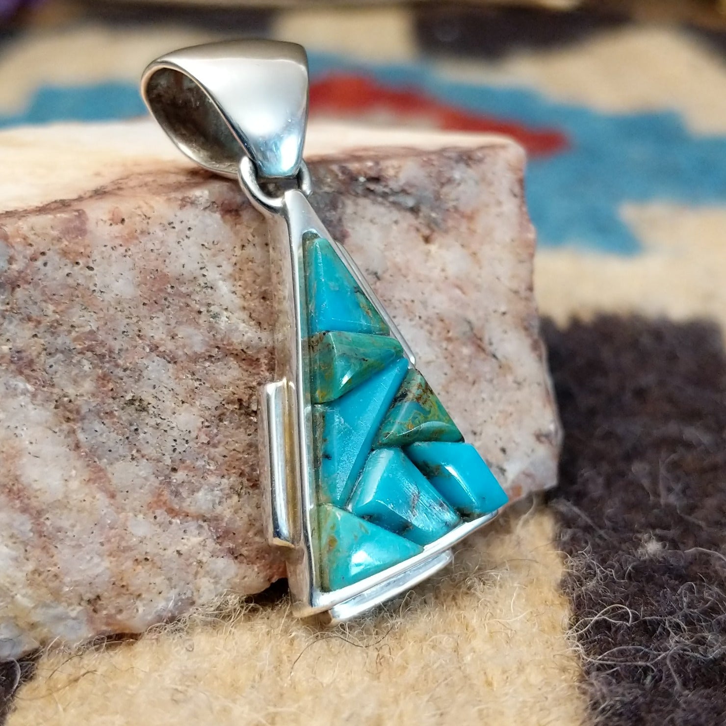 Sterling silver pendant with turquoise inlaid in the triangular bezel.