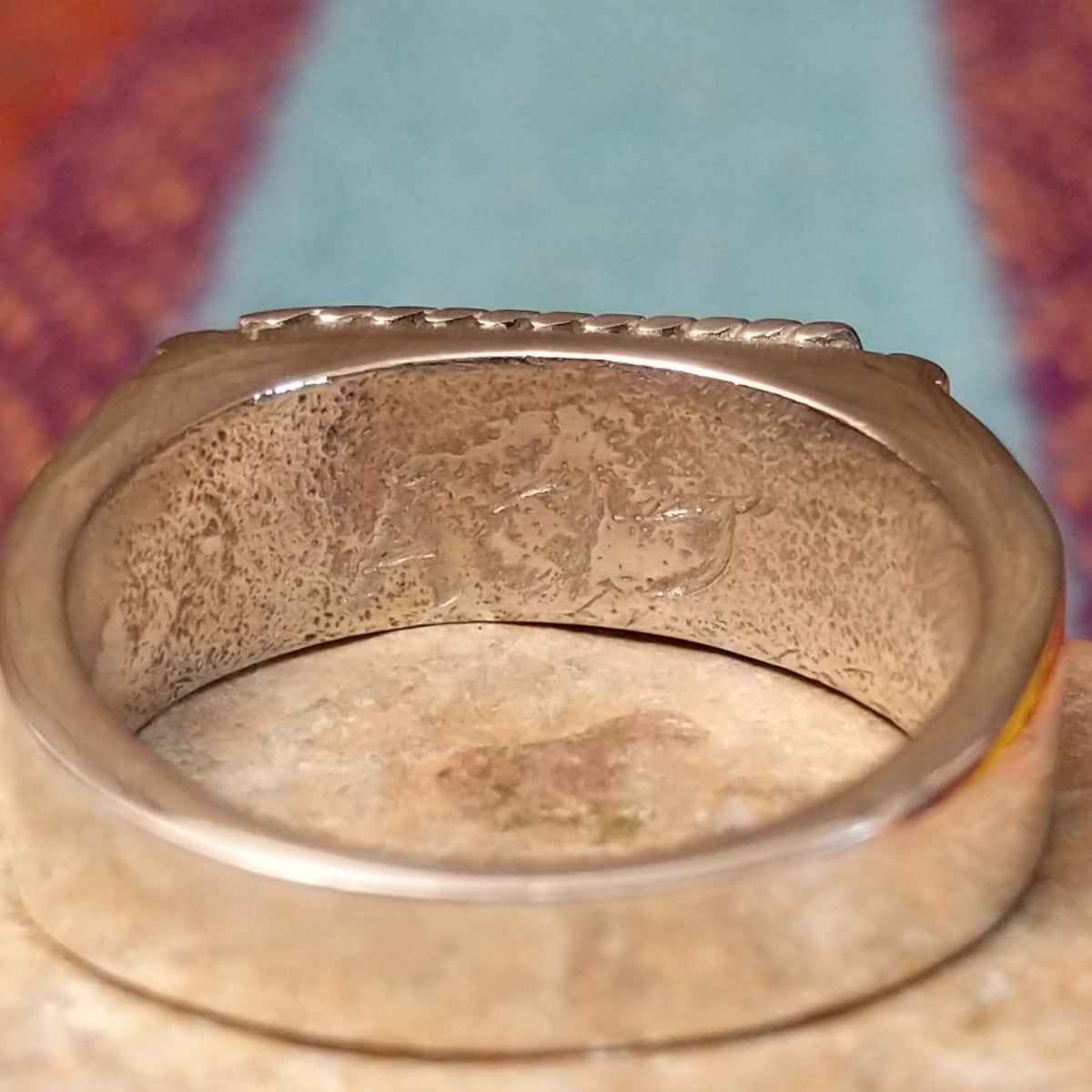 Navajo Turquoise Bar Ring by A.Q.J. featuring a rectangular bright blue turquoise stone with subtle matrix, framed by twisted-rope silverwork and decorative stamped details; artisan initials.