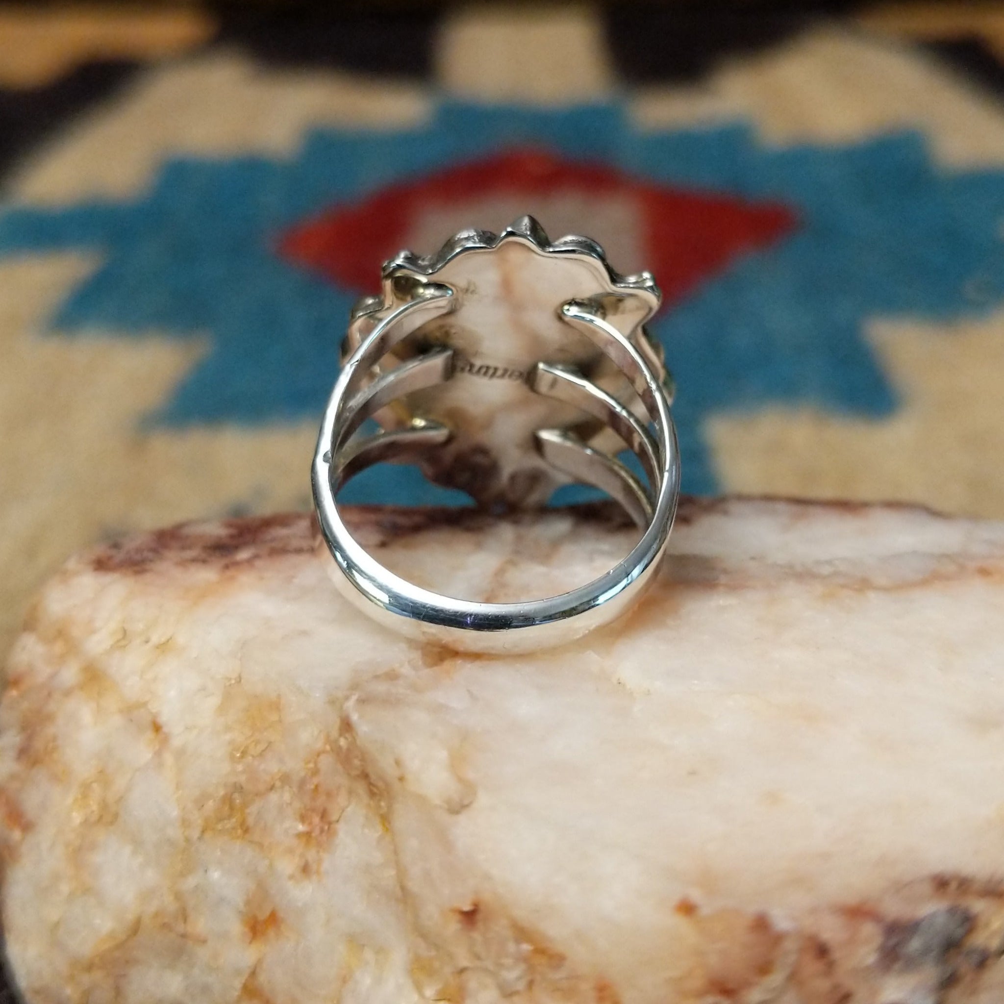 Navajo turquoise bear paw shadowbox ring, featuring a round blue turquoise stone set in a handcrafted sterling silver bear paw design with a dimensional shadowbox setting. Underside view.