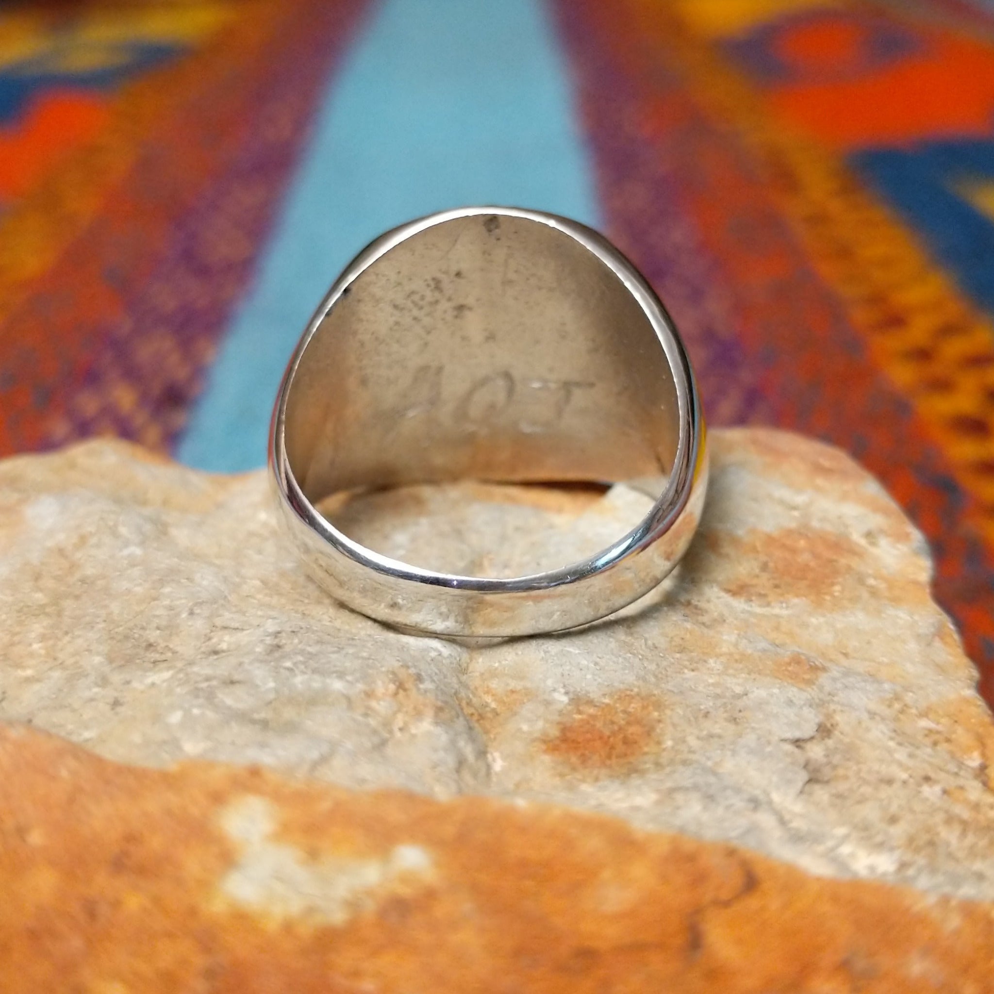 Navajo Turquoise Circle Ring by A.Q.J. featuring a large round turquoise stone with natural dark matrix, framed by twisted rope detailing and set in polished Sterling Silver; underside view.