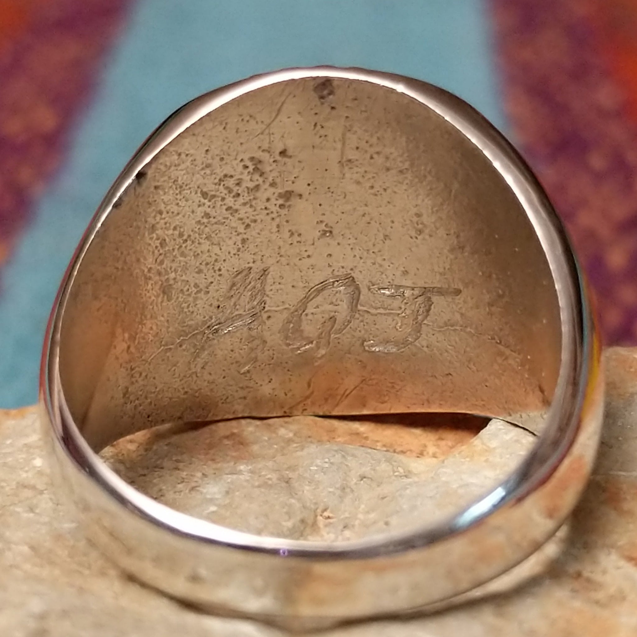 Navajo Turquoise Circle Ring by A.Q.J. featuring a large round turquoise stone with natural dark matrix, framed by twisted rope detailing and set in polished Sterling Silver; artisan initials.