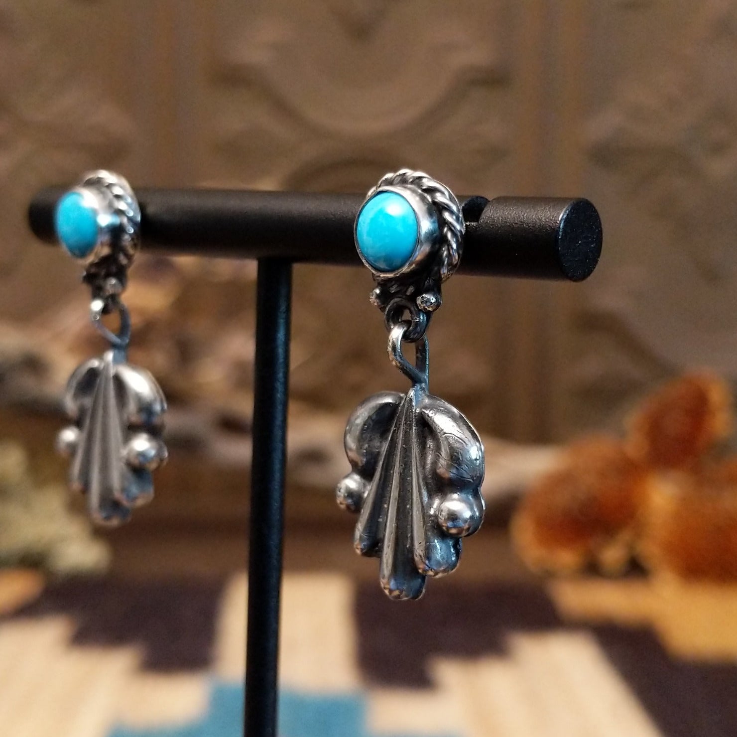 Sterling silver earrings with turquoise set in the posts, framed by twisted rope and unique silverwork designs.