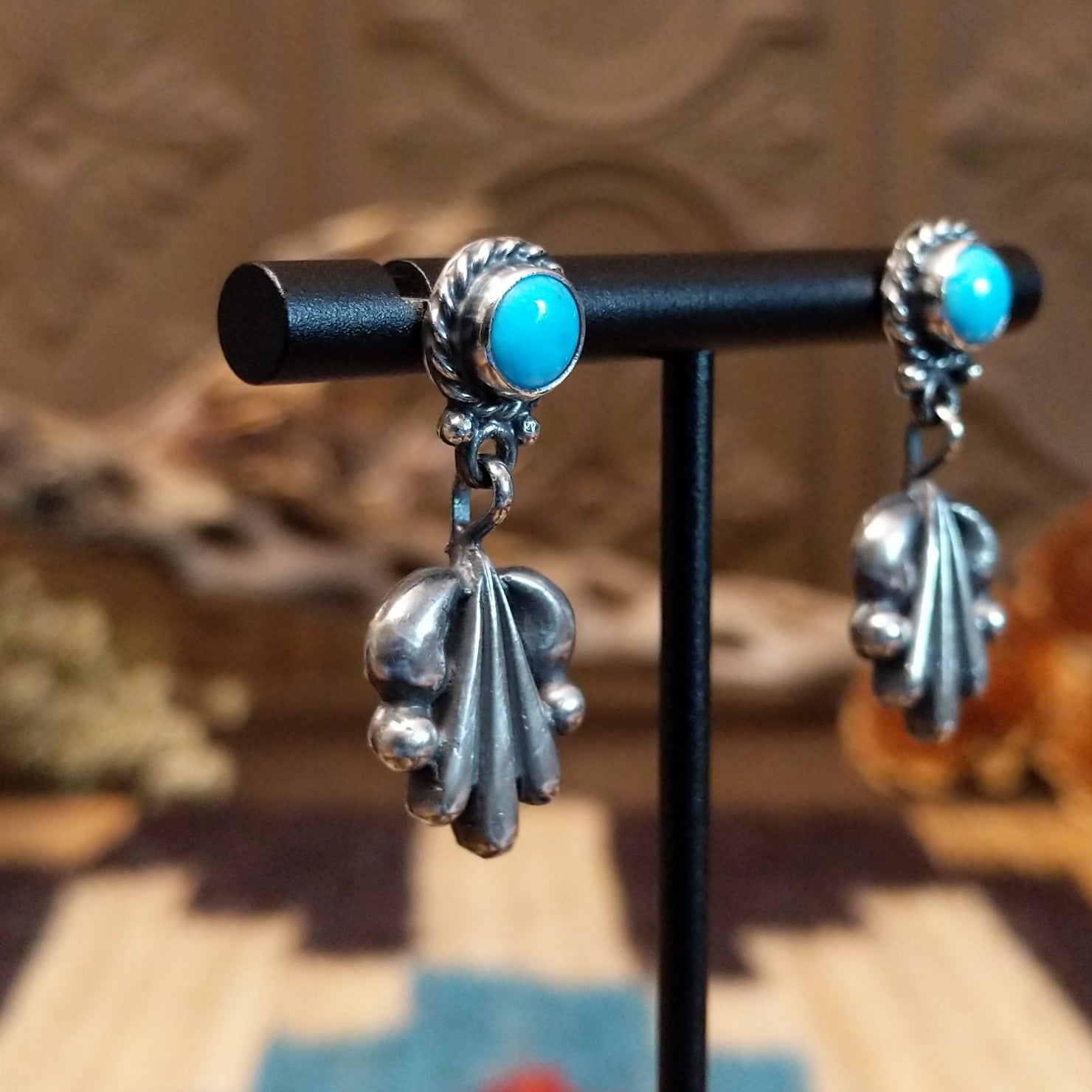Sterling silver earrings with turquoise set in the posts, framed by twisted rope and unique silverwork designs.