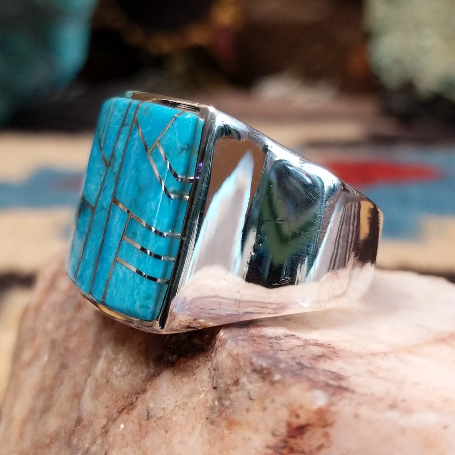 Sterling silver ring featuring a rectangular turquoise inlay and geometric channel work.