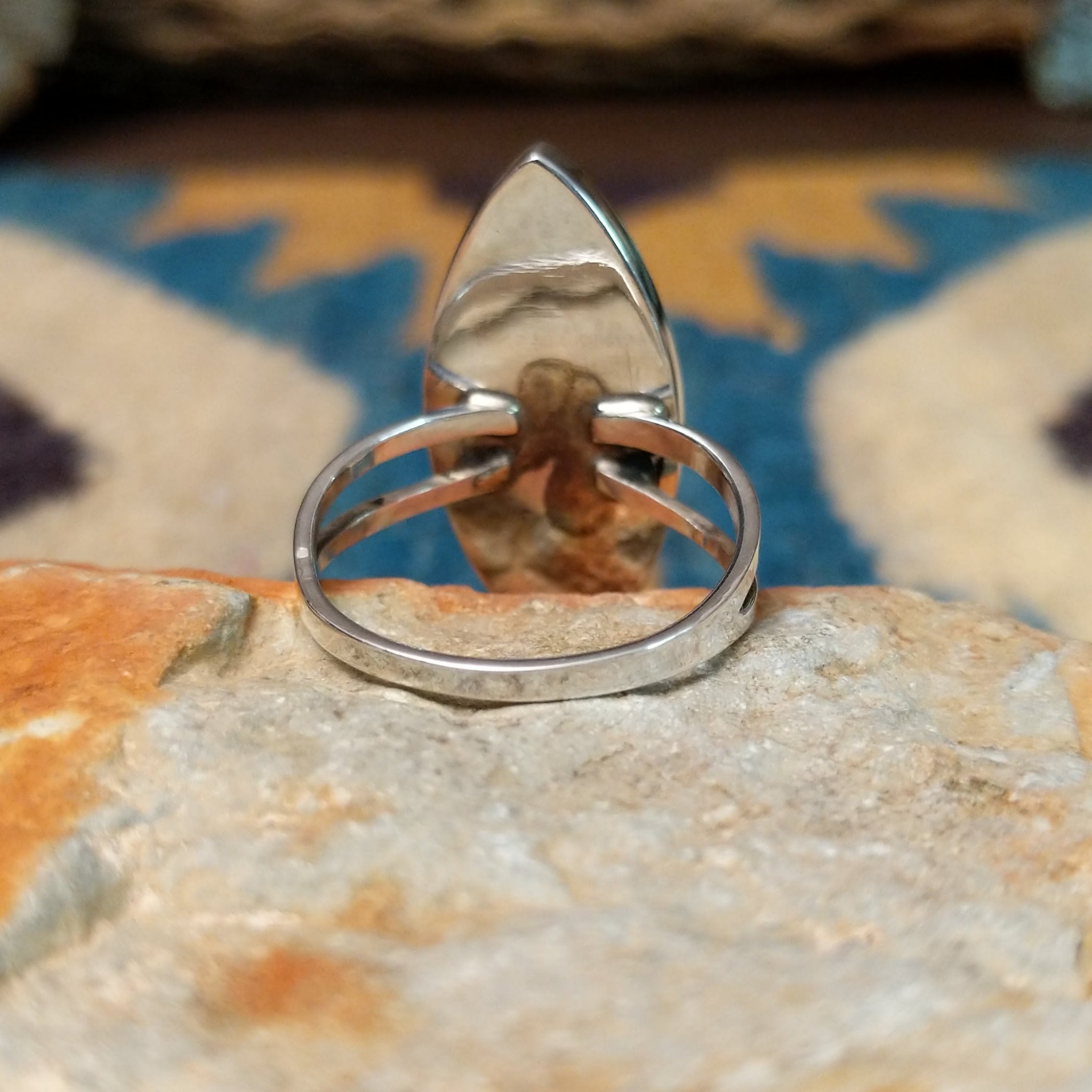 Handcrafted Navajo sterling silver navette ring featuring an elongated turquoise inlay with natural black matrix, set in a polished bezel with a split shank design; underside view.