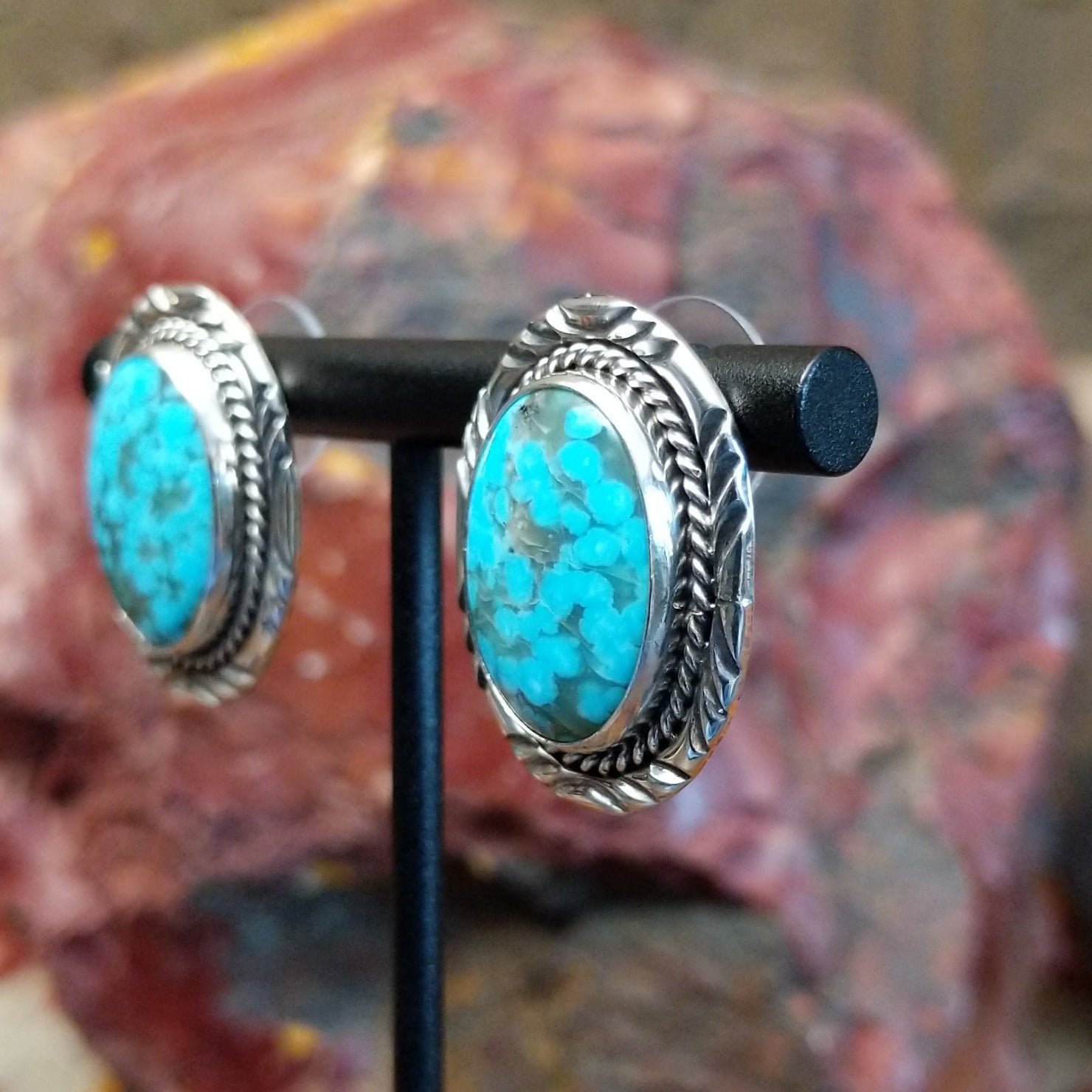 Sterling silver earrings with turquoise set in the bezels, framed by twisted rope and intricate stamping.