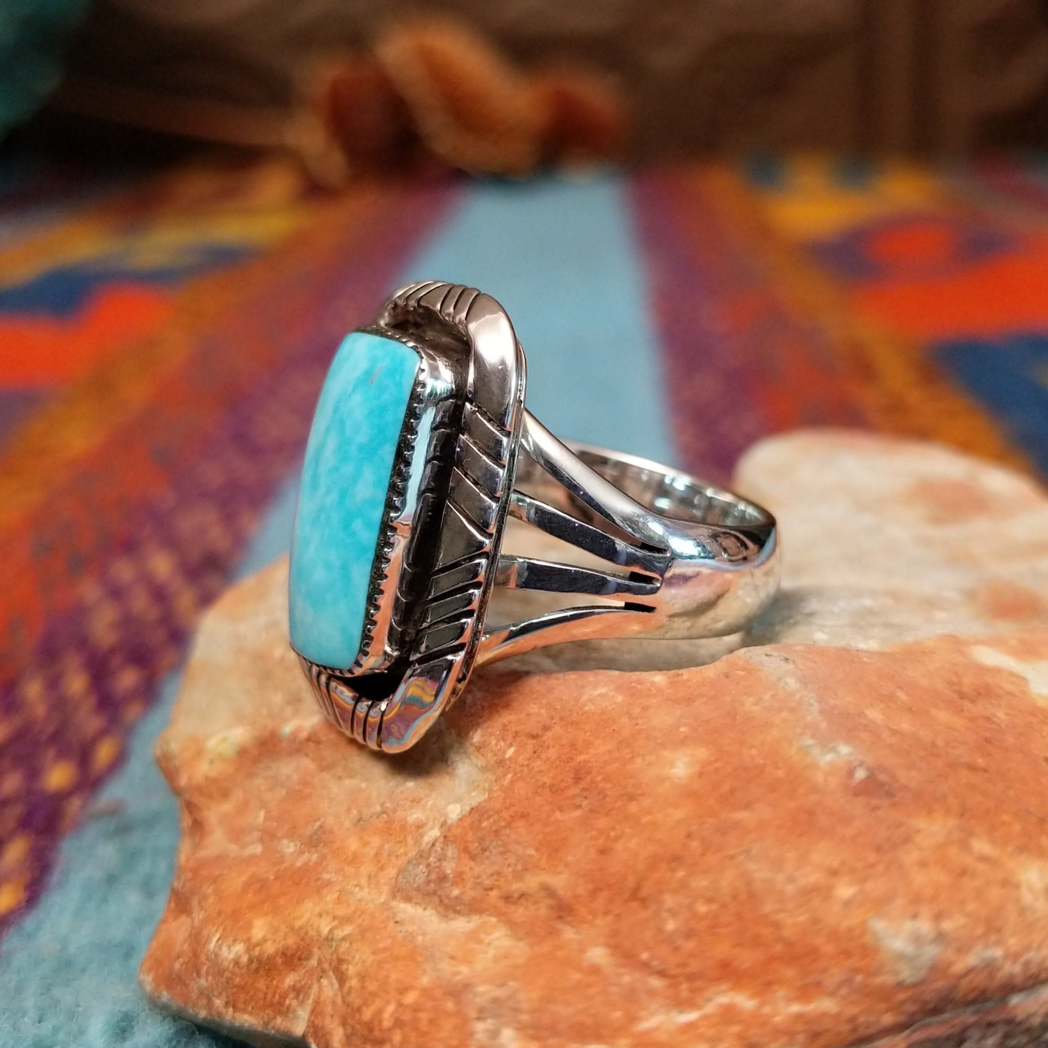 Navajo Turquoise Rectangle Ring featuring a large rectangular turquoise stone set in Sterling Silver with bold geometric stamped detailing and a split-shank band; side view.