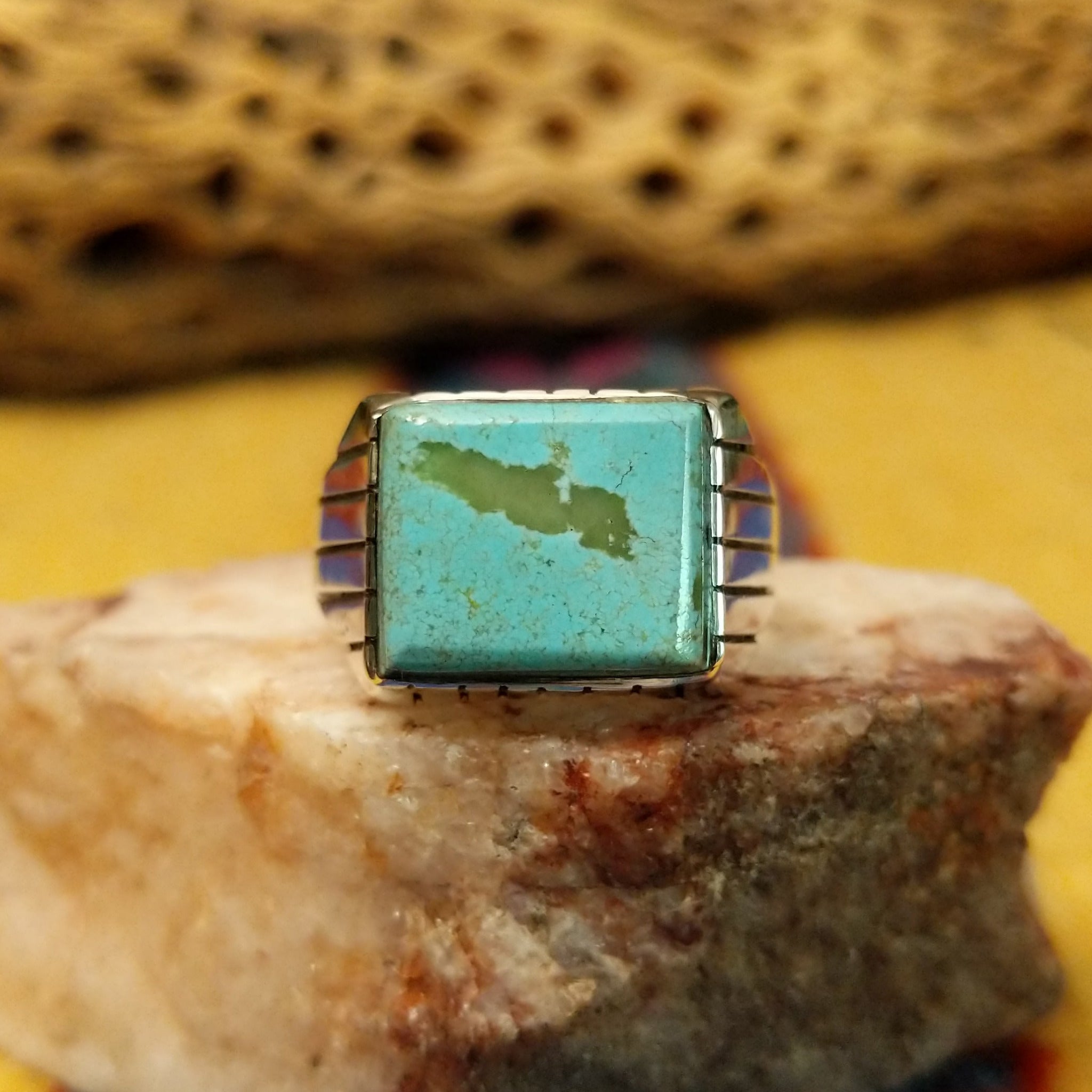Navajo turquoise ring by R., featuring a square turquoise stone with natural blue and green tones set in a handcrafted sterling silver band with stepped side accents.