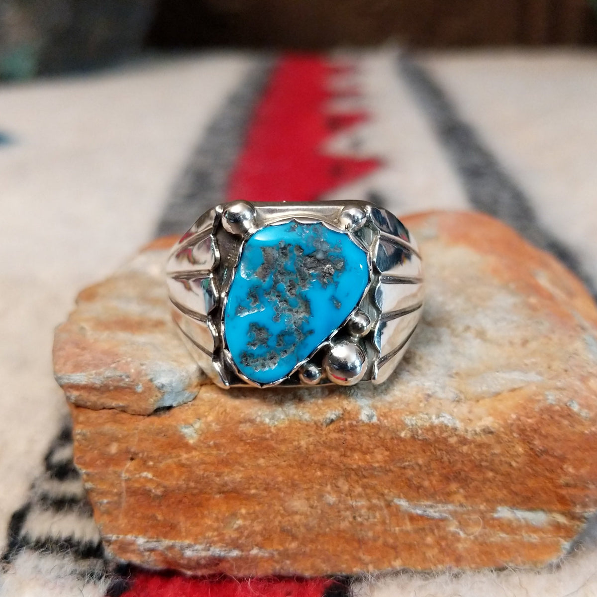 Navajo turquoise ring by S. with silver drops and tapered band.