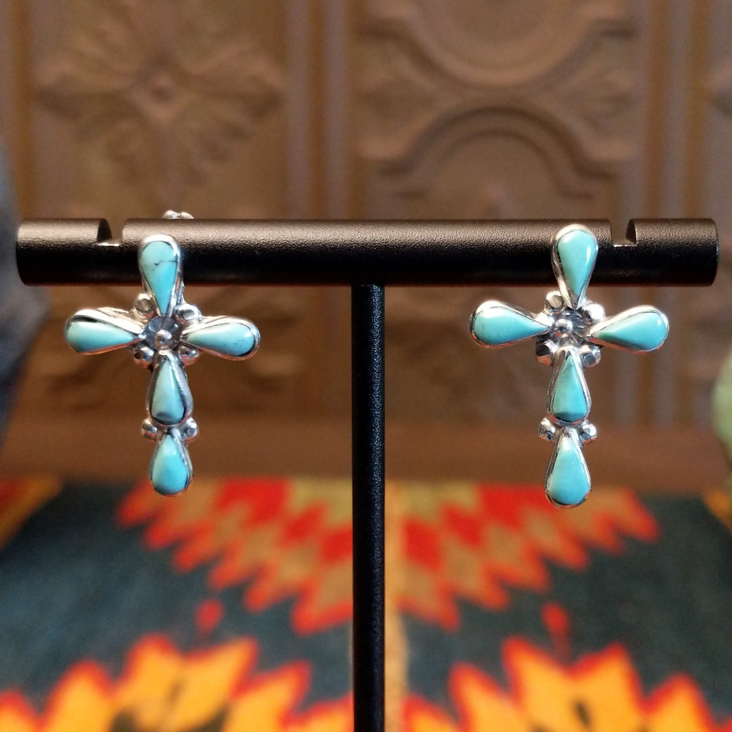 Sterling silver cross earrings with turquoise set in teardrop-shaped bezels.