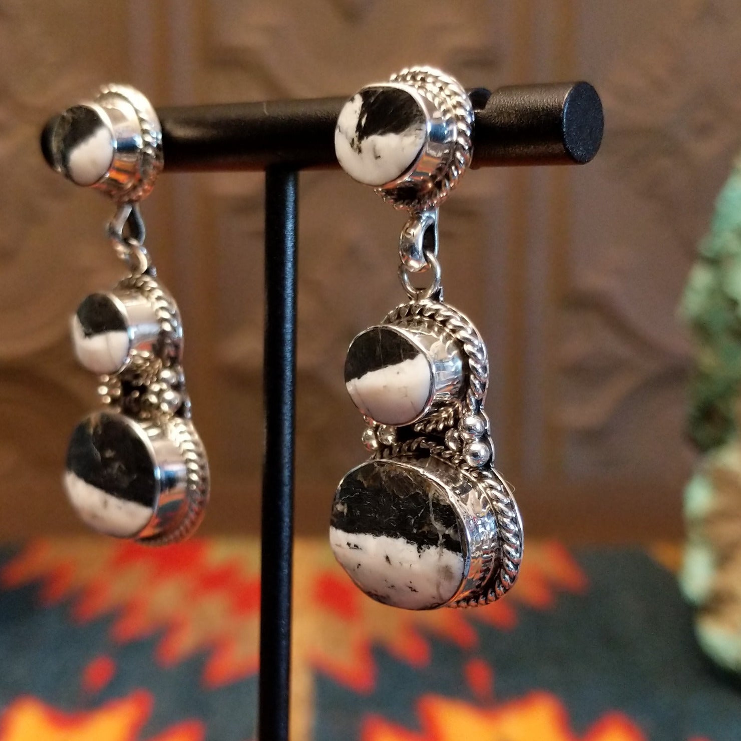 Sterling silver dangle earrings with white buffalo set in the bezels, framed by twisted rope and dotted accents.