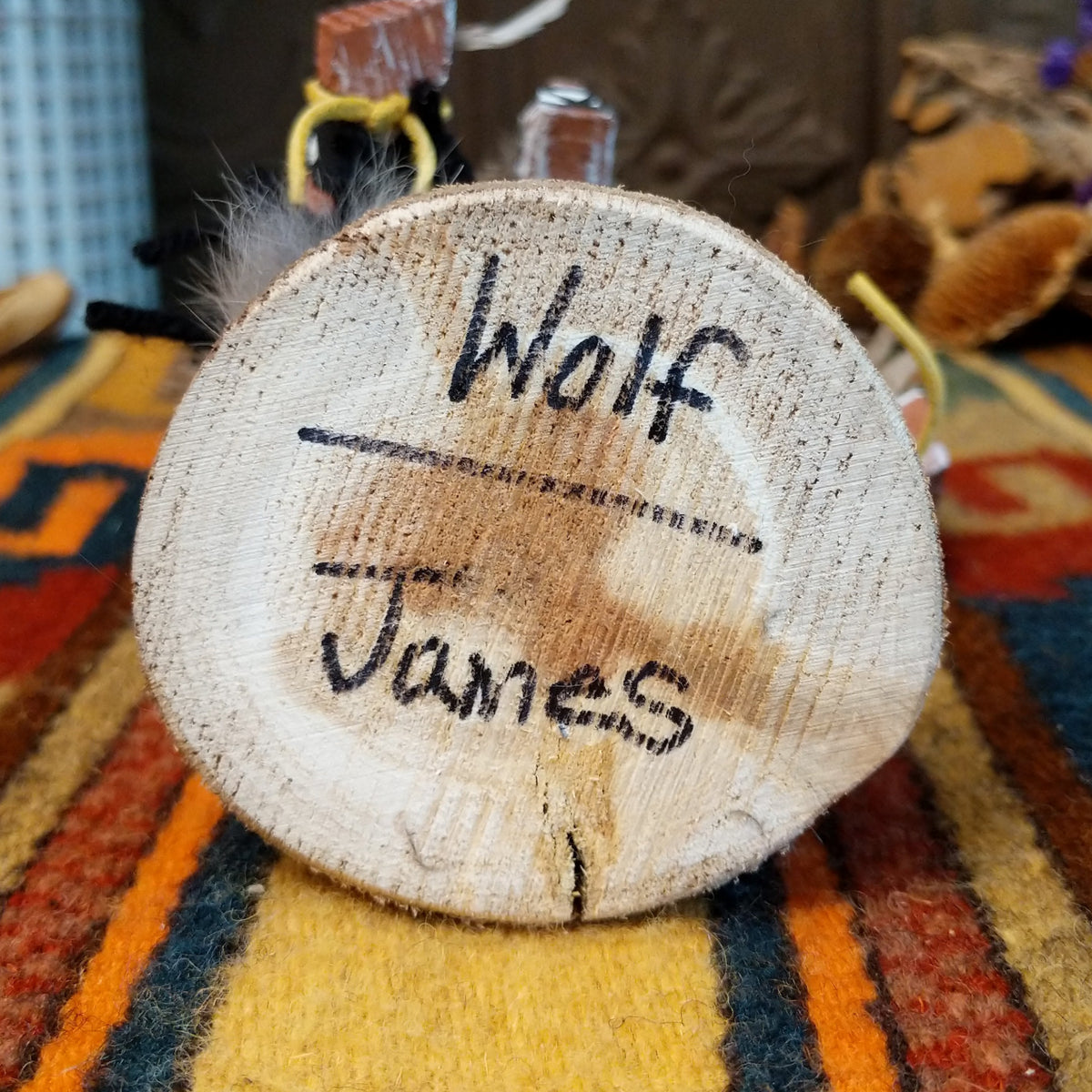 Underside of Navajo Wolf Kachina doll base with handwritten figure name and artist surname.