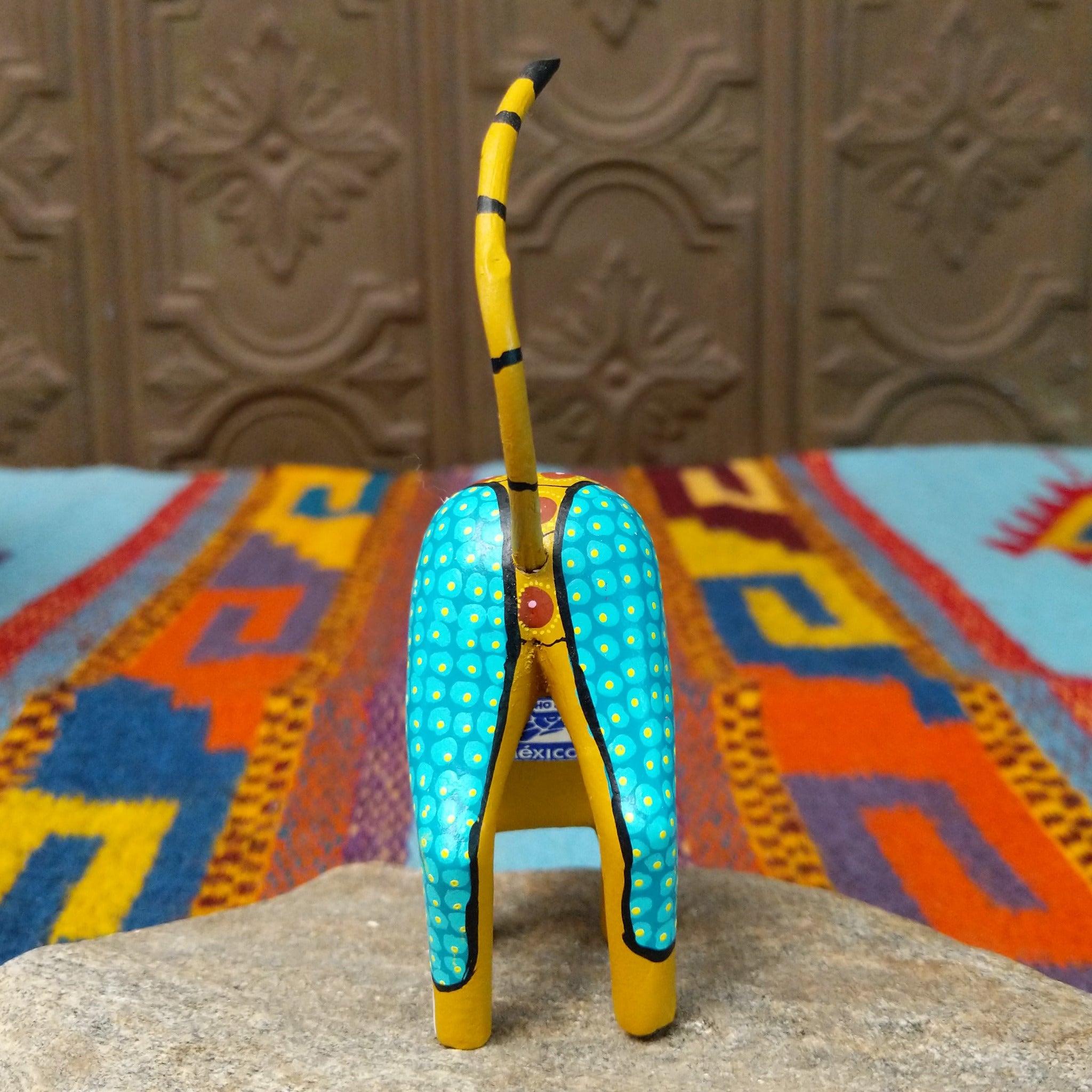 Oaxacan cat wood carving with a tall upright body, detachable parts, and colorful hand-painted geometric patterns.