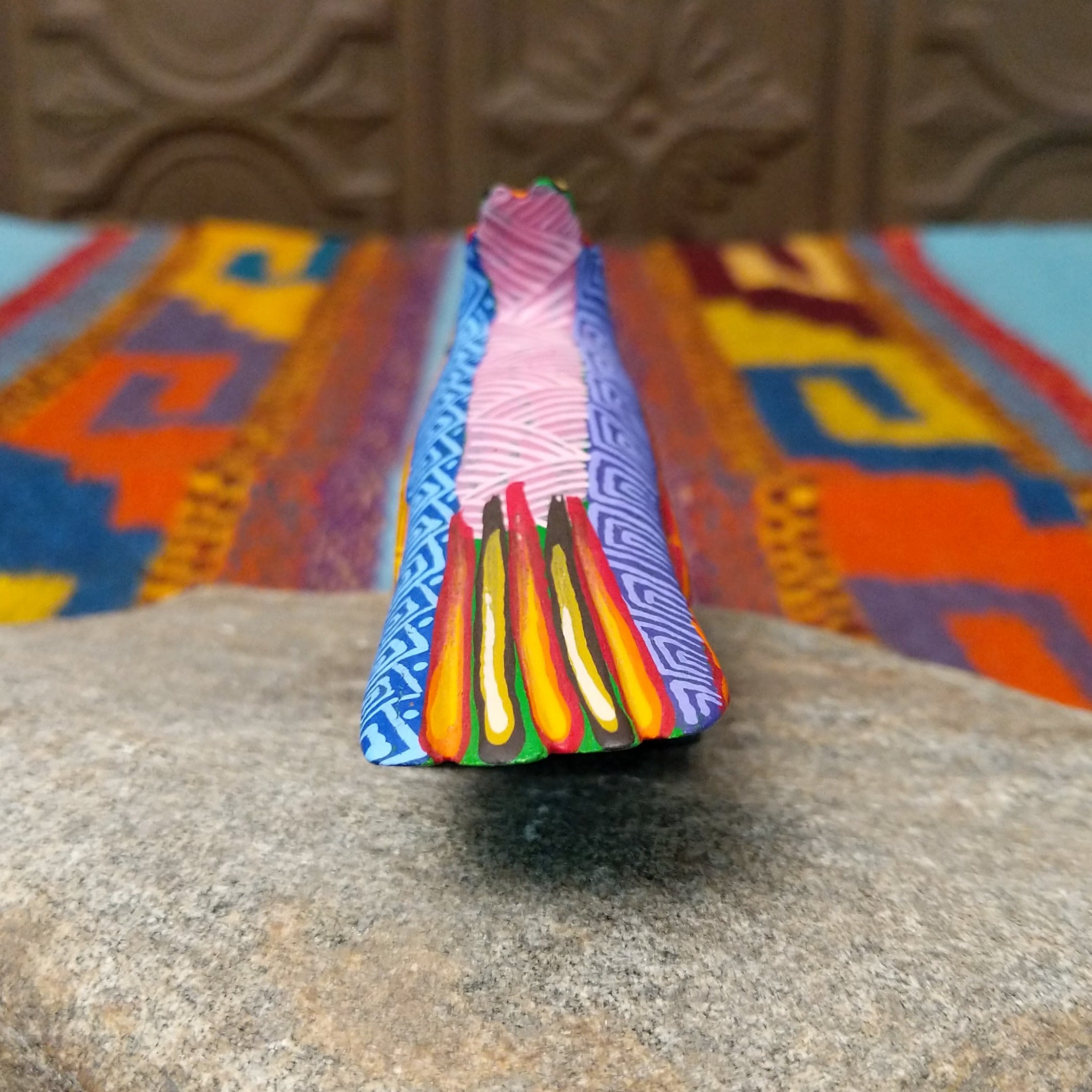 Oaxacan roadrunner wood carving by Julia Calvo Olivera with a long yellow beak, swept-back crest, and multicolored geometric patterns.