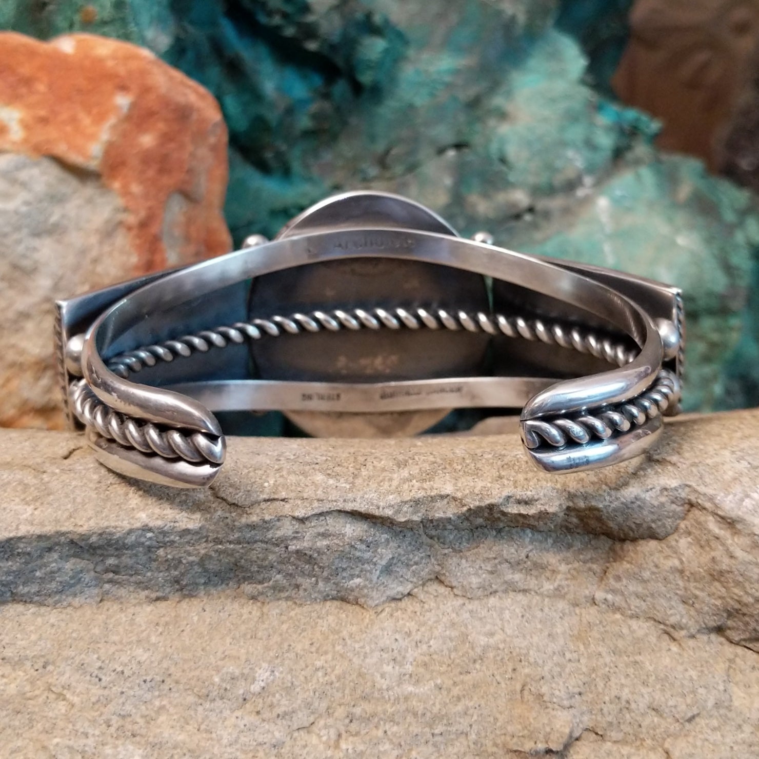 The rear of the cuff reveals a polished sterling silver band with the twisted rope detailing.