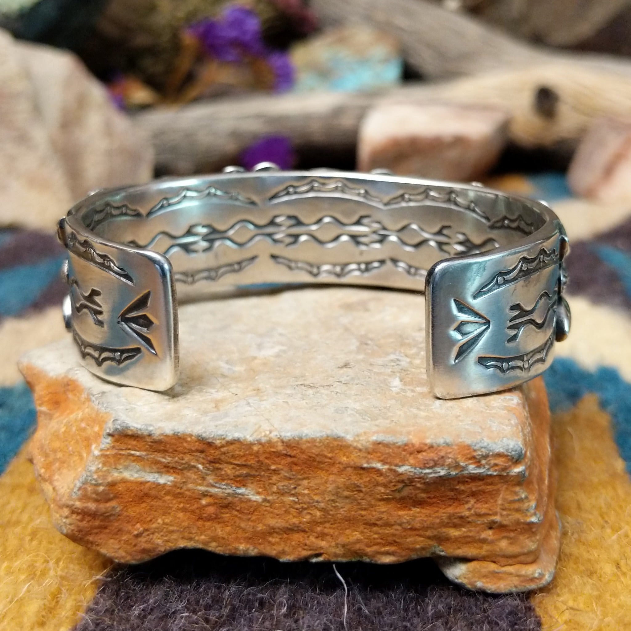 Handcrafted sterling silver cuff by Andrew Gordon featuring a Kingman turquoise cabochon with a twisted rope bezel, surrounded by ornate conchos, fan motifs, silver beadwork, and hand-stamped Southwestern details; underside view.
