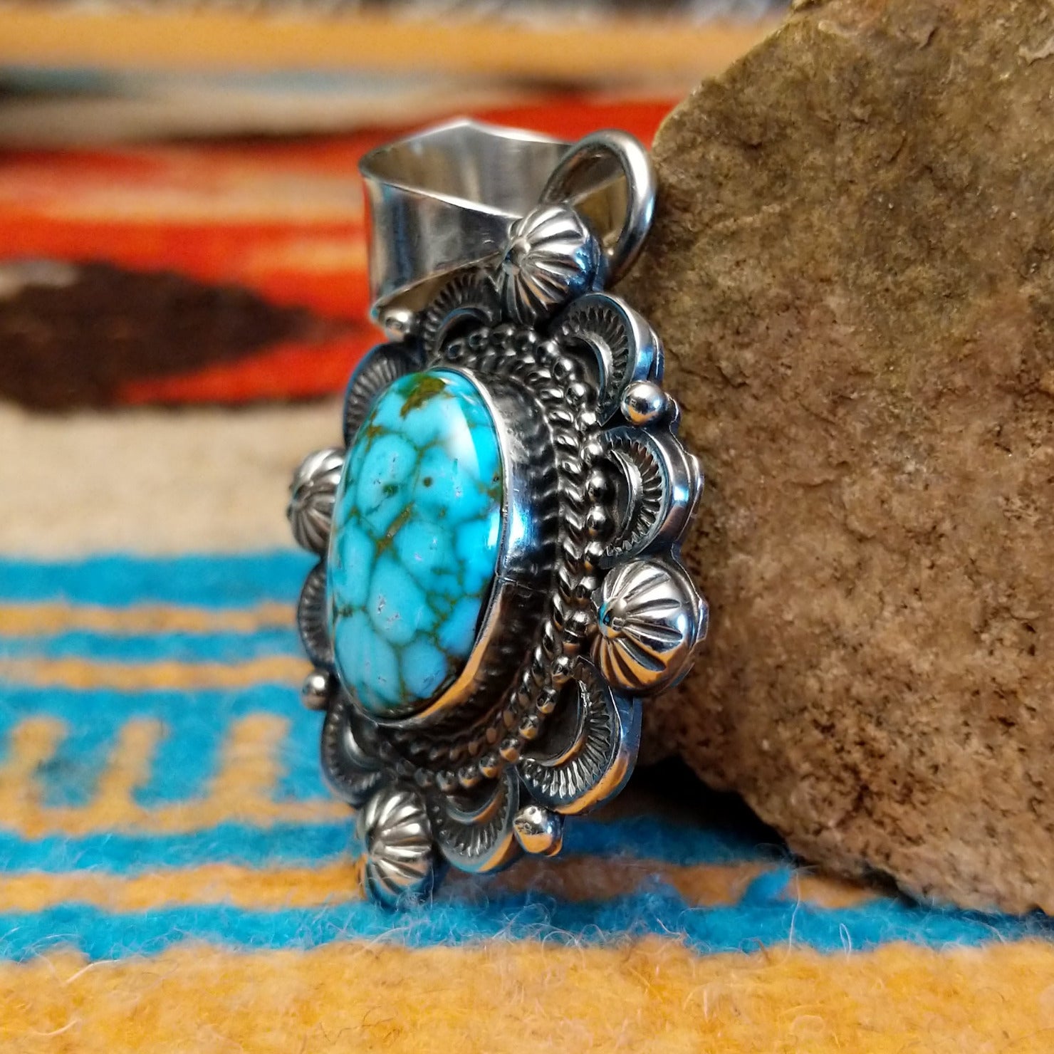 Sterling silver pendant with Kingman turquoise set in the oval bezel, framed by the ornate setting with twisted rope and dotted accents.