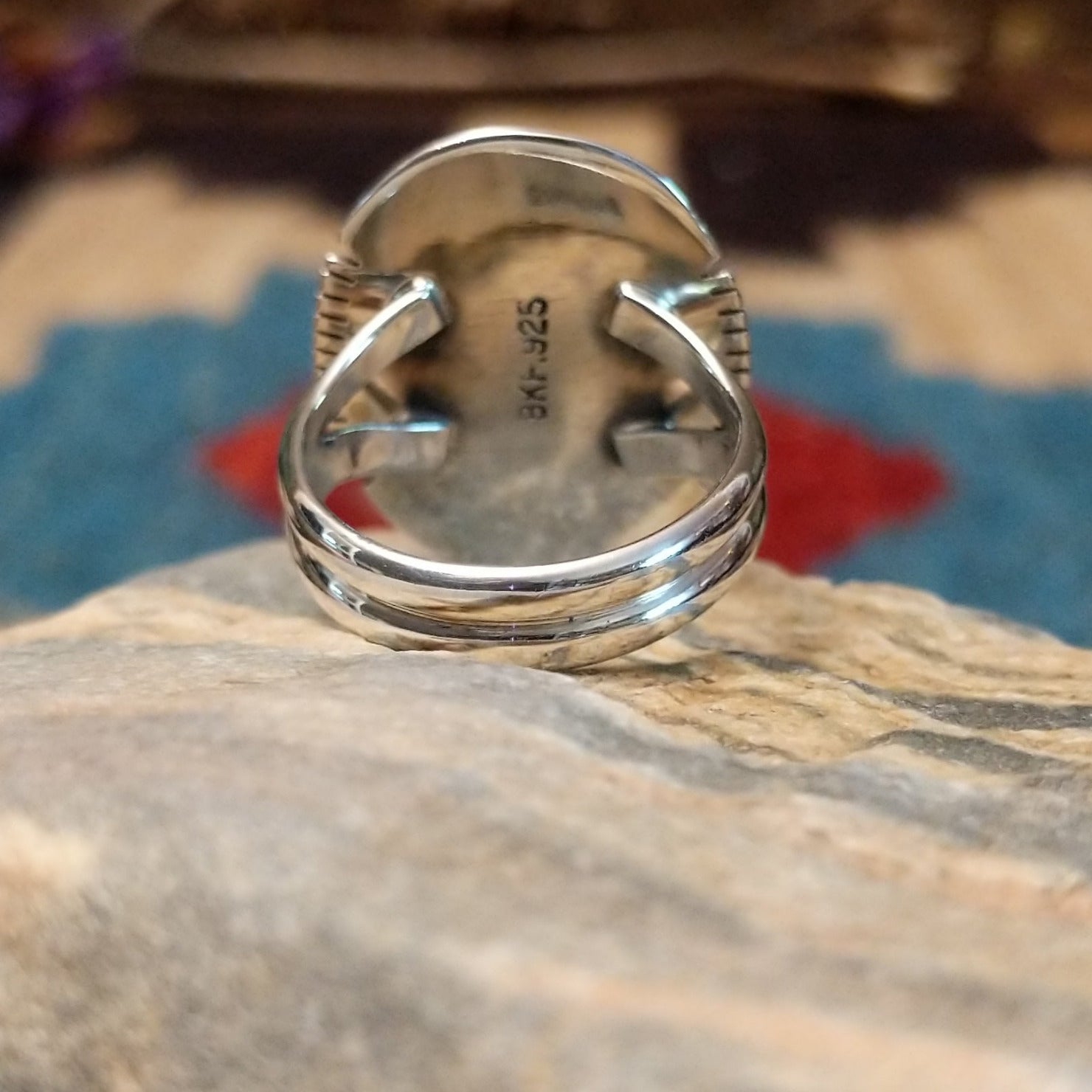 Sterling silver ring with large charoite stone set in an oval bezel, framed by twisted rope and stamped setting.