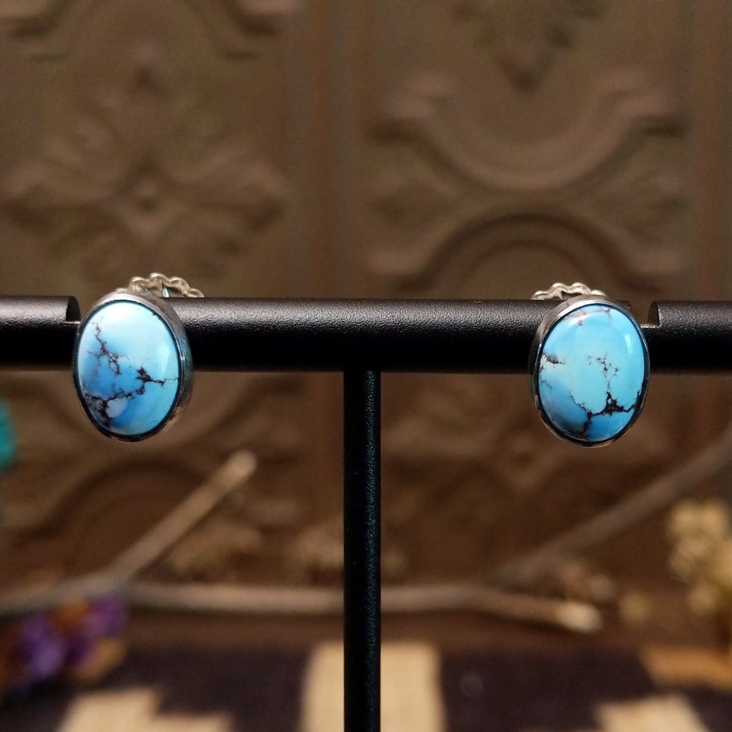 Sterling silver earrings with turquoise set in oval bezels.