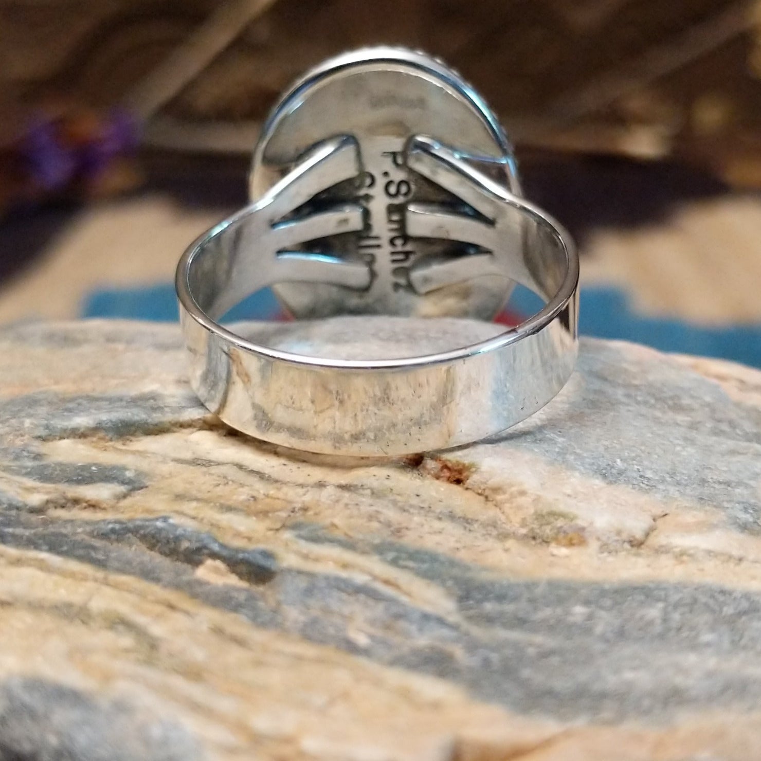 Sterling siler ring with turquoise set in the oval bezel, framed by twisted rope accents.