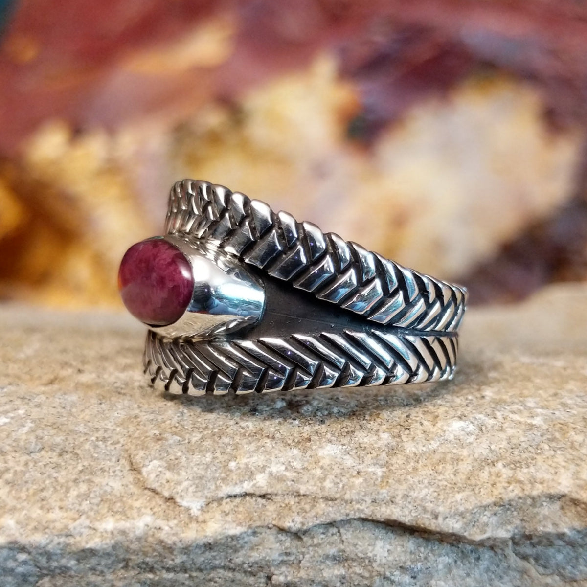 Oval purple spiny oyster shell set in a silver bezel with a braided sterling silver band.