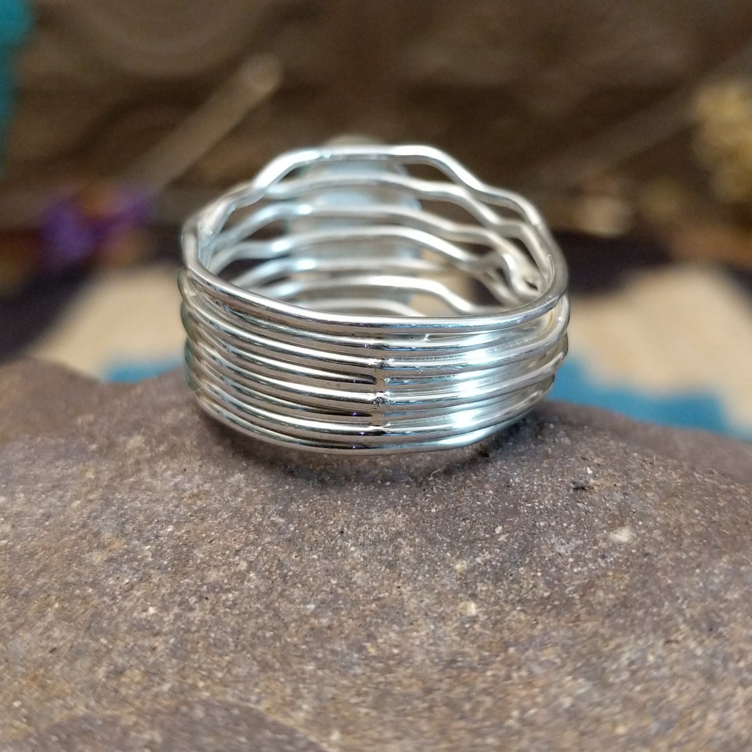 Sterling silver ring with Sonoran gold turquoise set in an oval bezel and strands of silver creating the band.