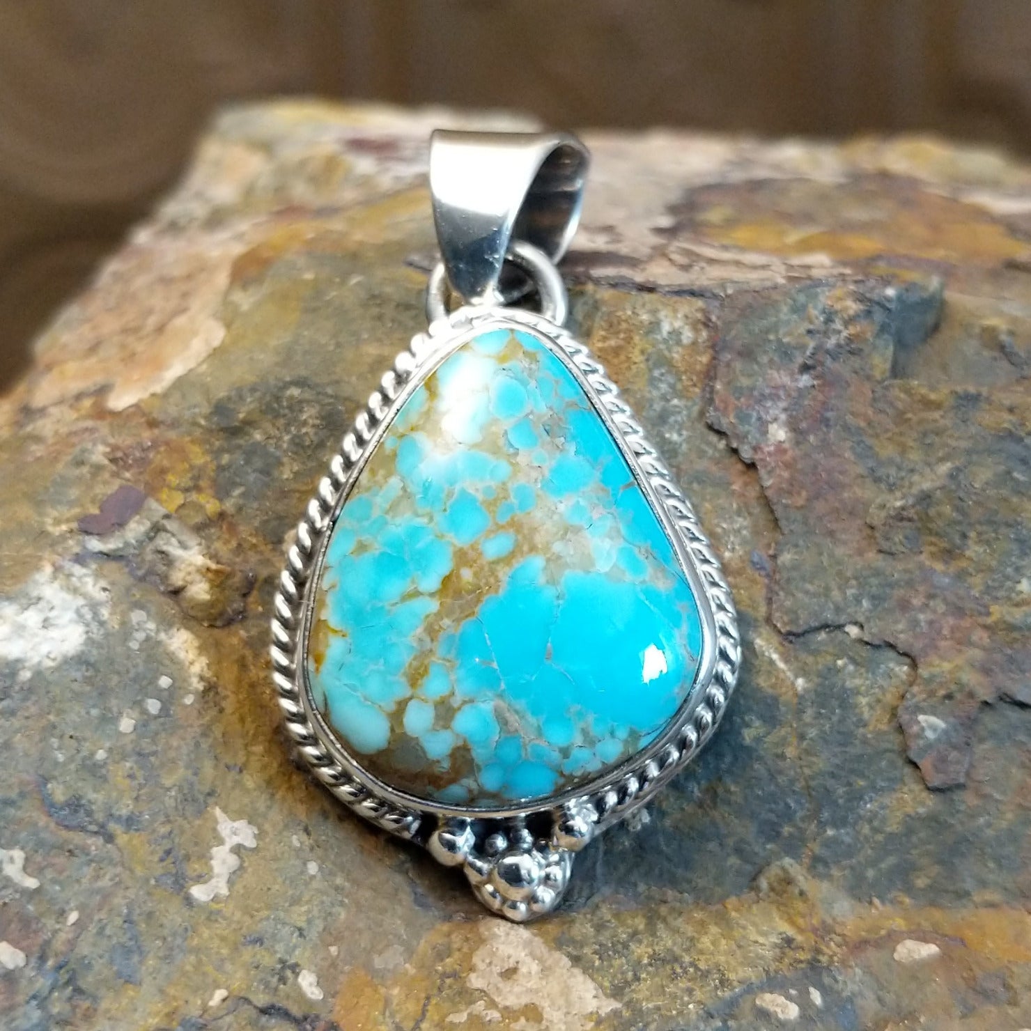 Genuine #8 Turquoise set in sterling silver with a rope accent detail.