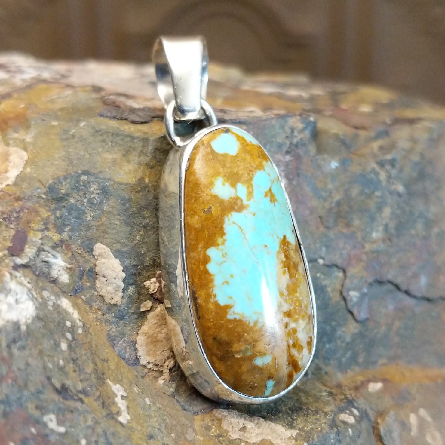 Handcrafted by Navajo artist L.P., this elliptic pendant features genuine #8 Turquoise set in sterling silver.
