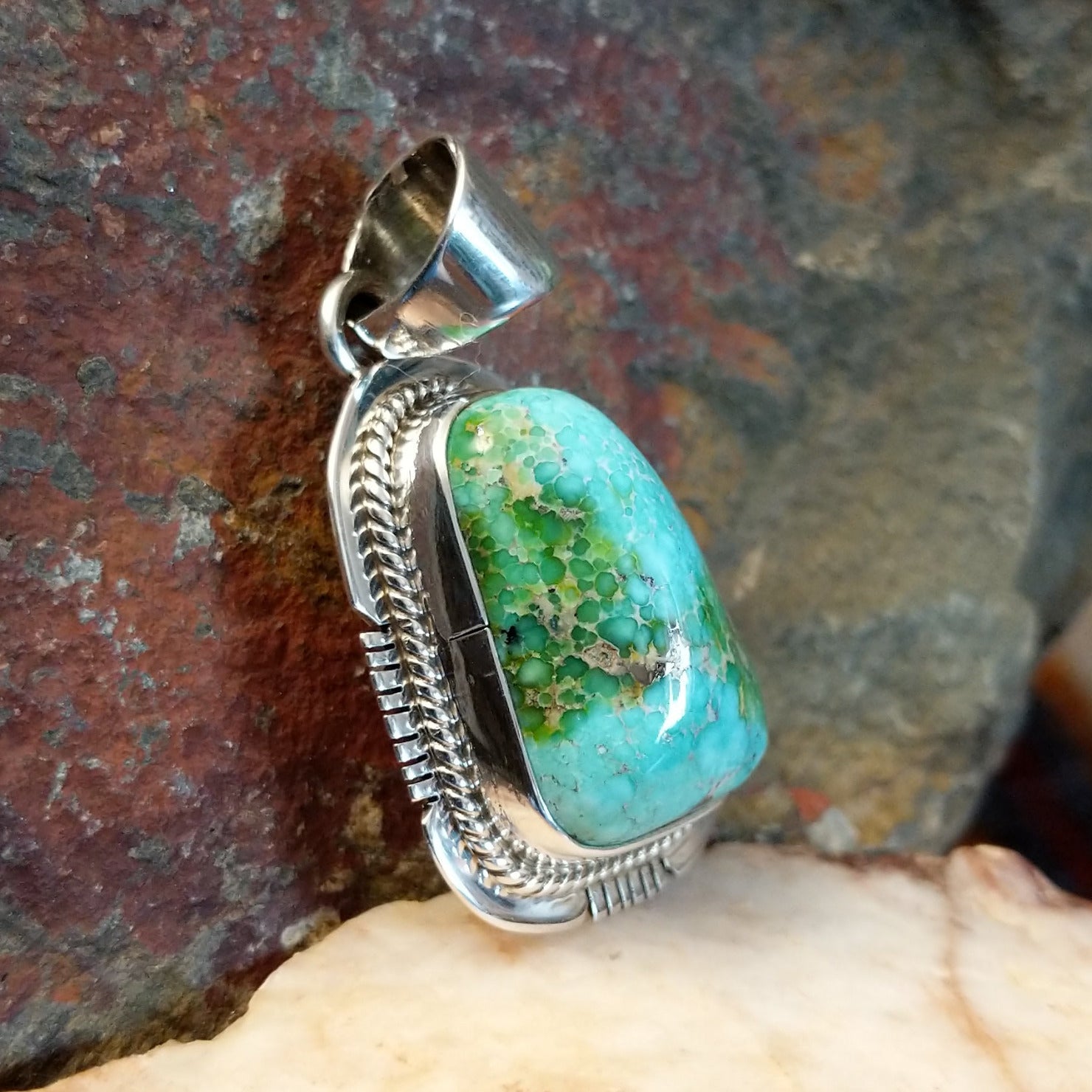 Sonoran Gold turquoise pendant by Navajo artist Burt Francisco, handcrafted in sterling silver with an etched setting. Side view.