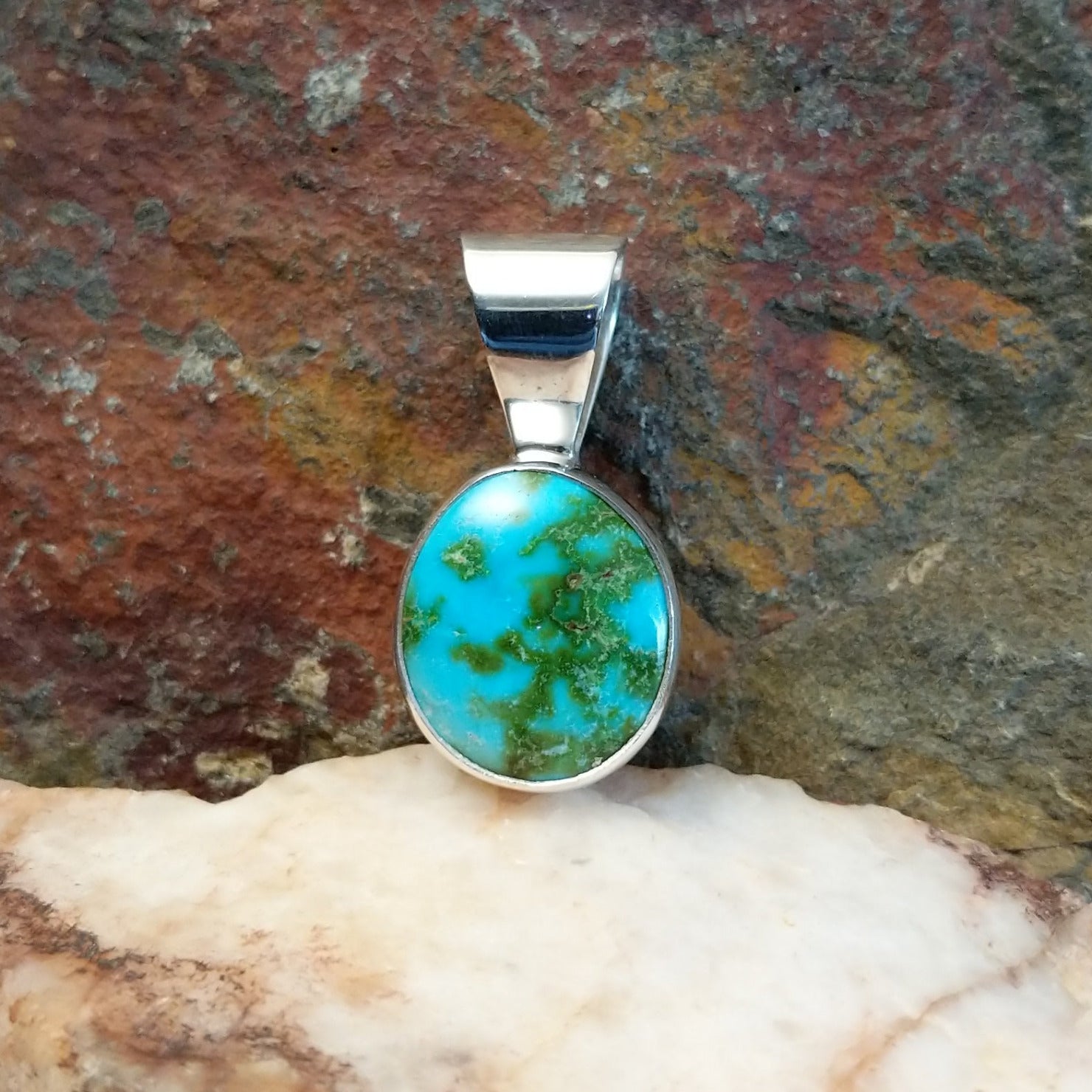 Sonoran Gold turquoise round pendant by Navajo artist Fred Guerro Jr., is handcrafted in sterling silver.