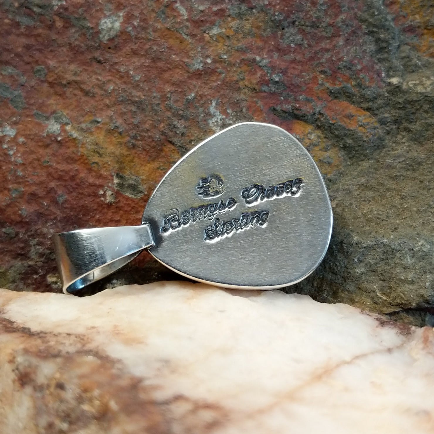 Artisan and Sterling Silver stamp on back of pendant.