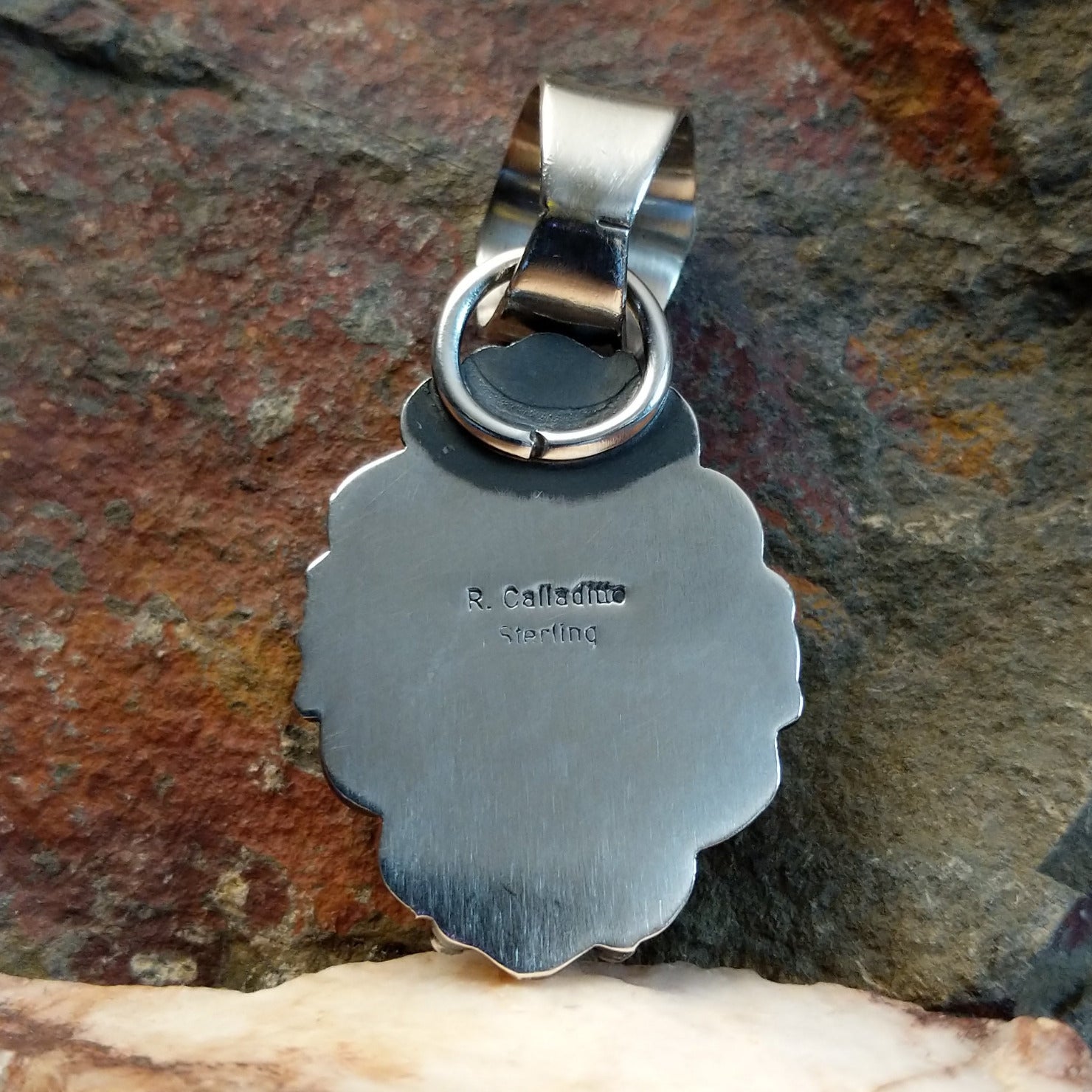 Artisan and Sterling Silver stamp on back of pendant.